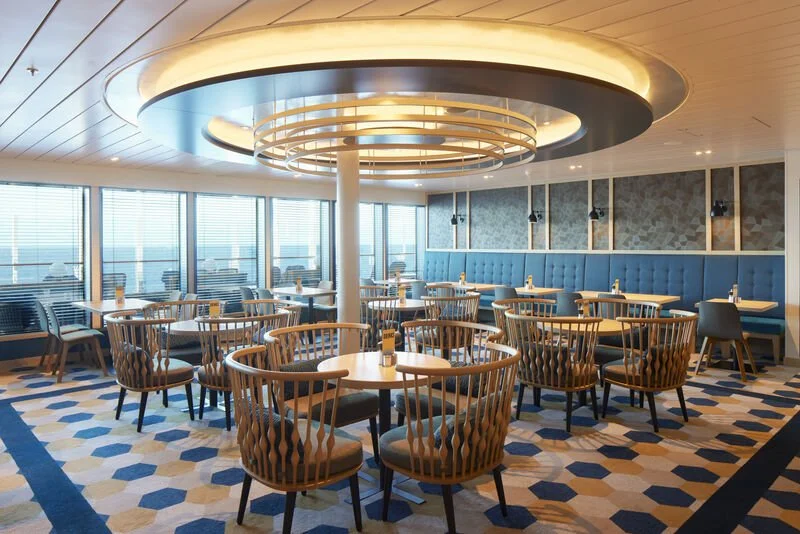 The Quays on P&O Cruises Arvia with table seating and panoramic sea views.