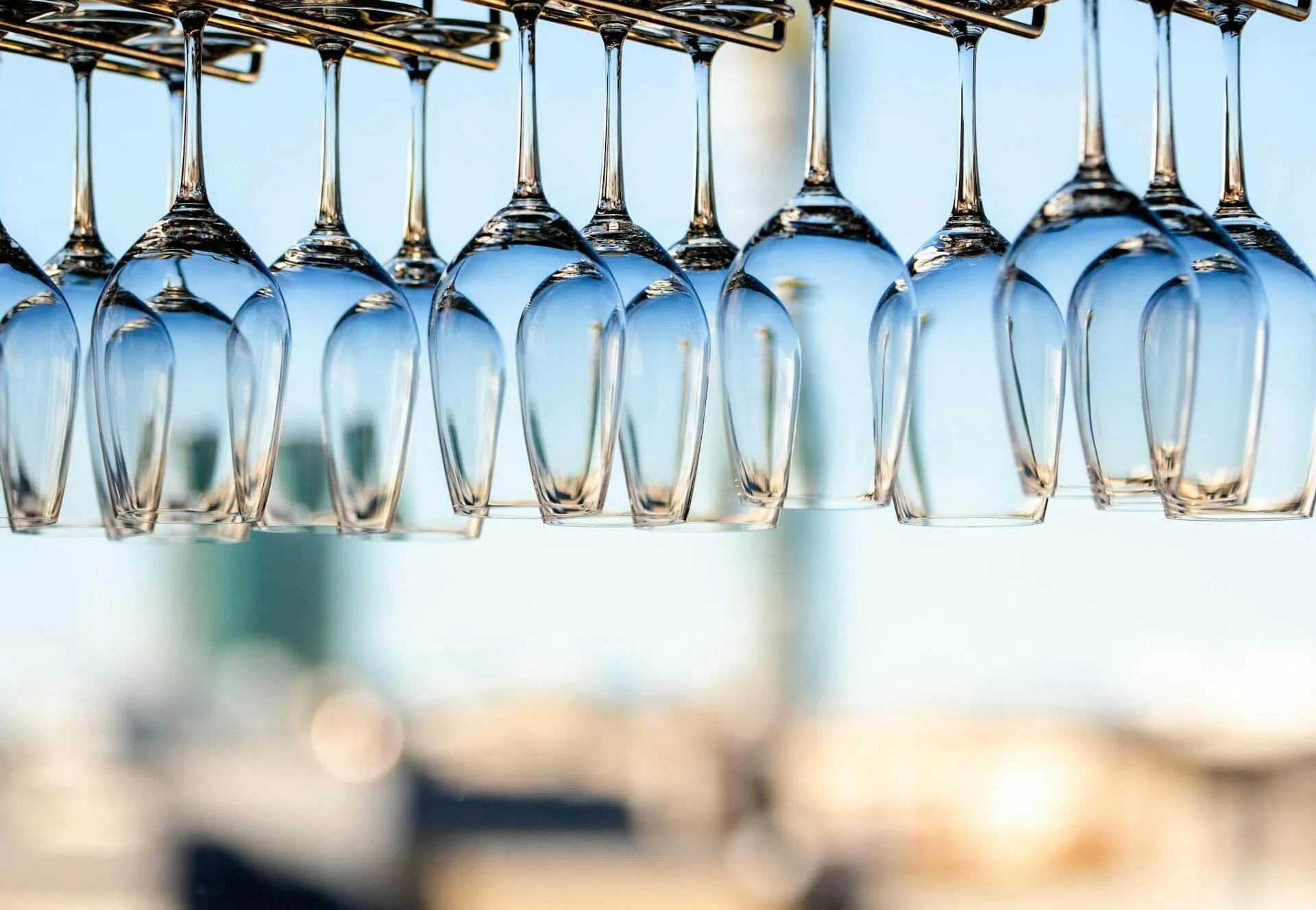 Selection of wine glasses hanging upside down over a bar