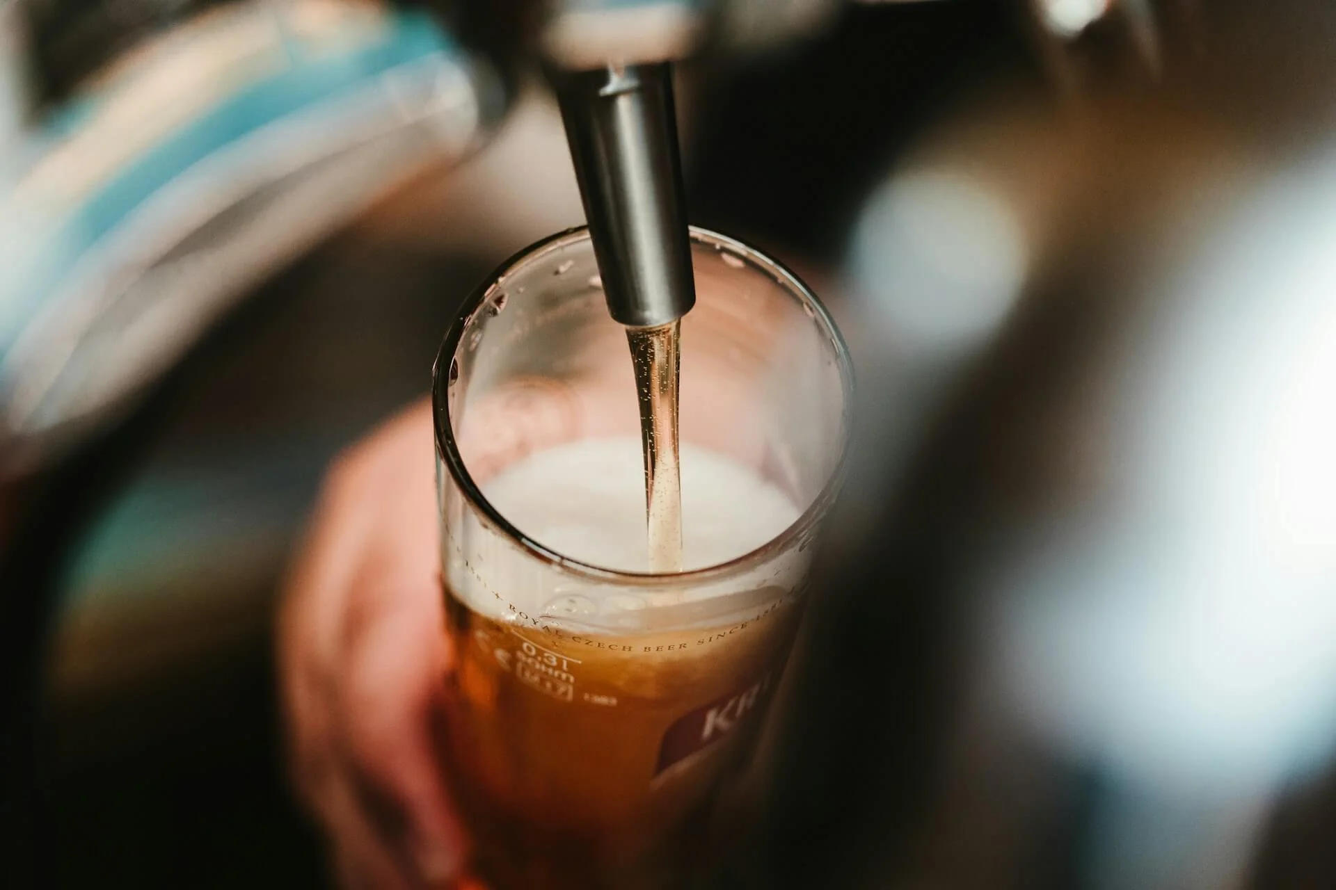 Pint of draught beer being poured from tap