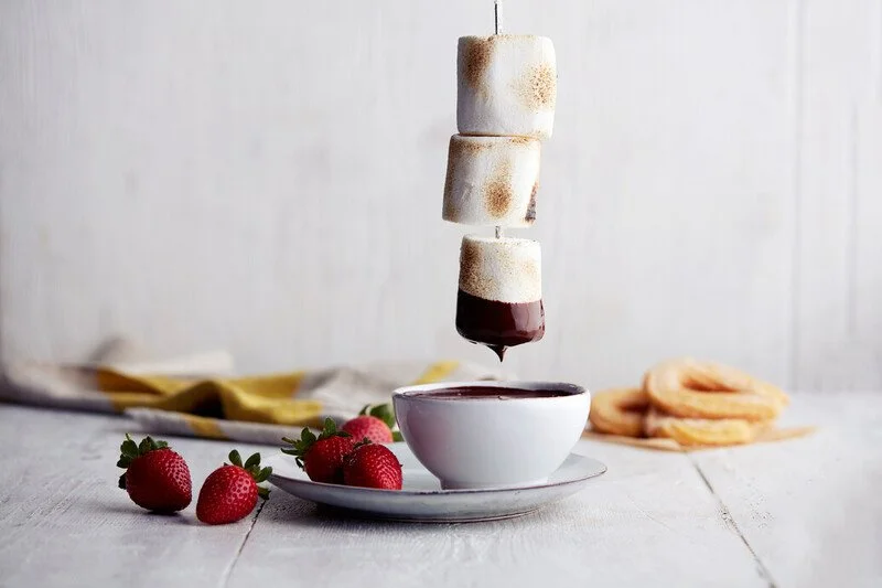 Marshmallow kebab being dipped into chocolate fondue with strawberries from The Beach House restaurant Menue on P&O Cruises