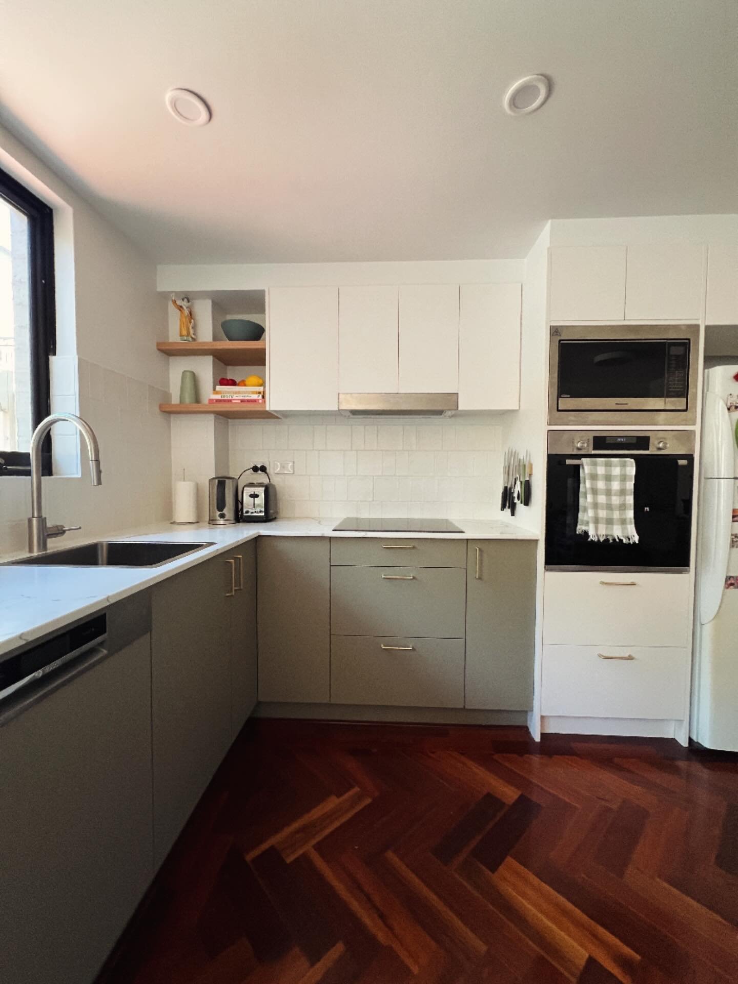 Take a look at another kitchen renovation we completed. After stripping out the outdated kitchen, we brought it back to life with fresh cabinets, elegant stone benchtops, an induction cooktop, a stylish tiled splashback, and clever custom shelving to