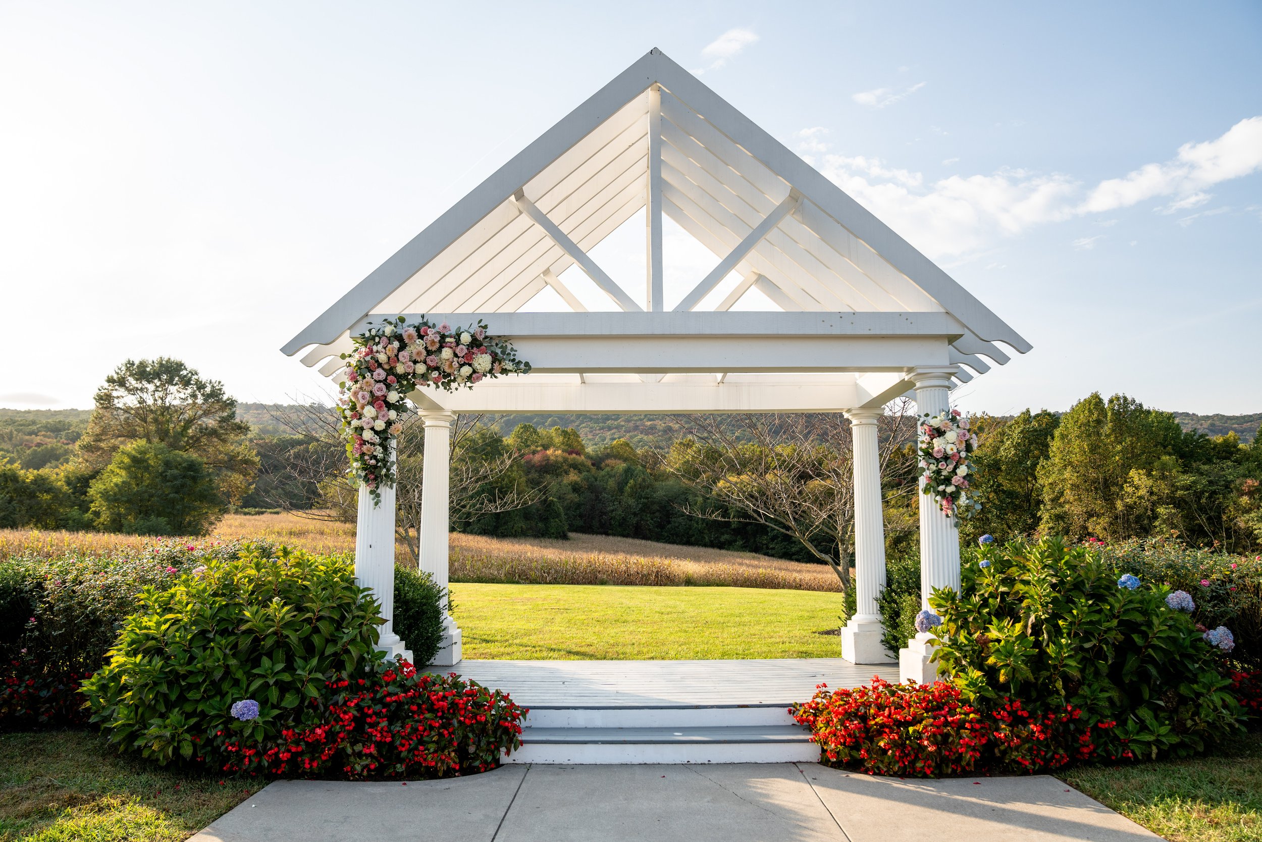 A beautiful ceremony site at a wedding on a sunny, clear sky day with mountains in the background.