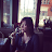 Person drinking from a glass in a restaurant setting.