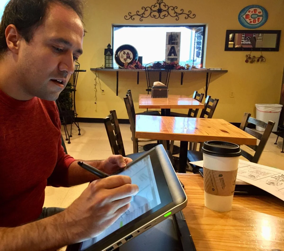 Quad-City cartoonist Jason Platt sketches a comic strip on his Wacom tablet Monday at Java Java Cafe in Davenport. Earlier this fall, the 43-year-old father released a new book of his stories and illustrations titled, “mister & Me: Of Castles & Kings.”