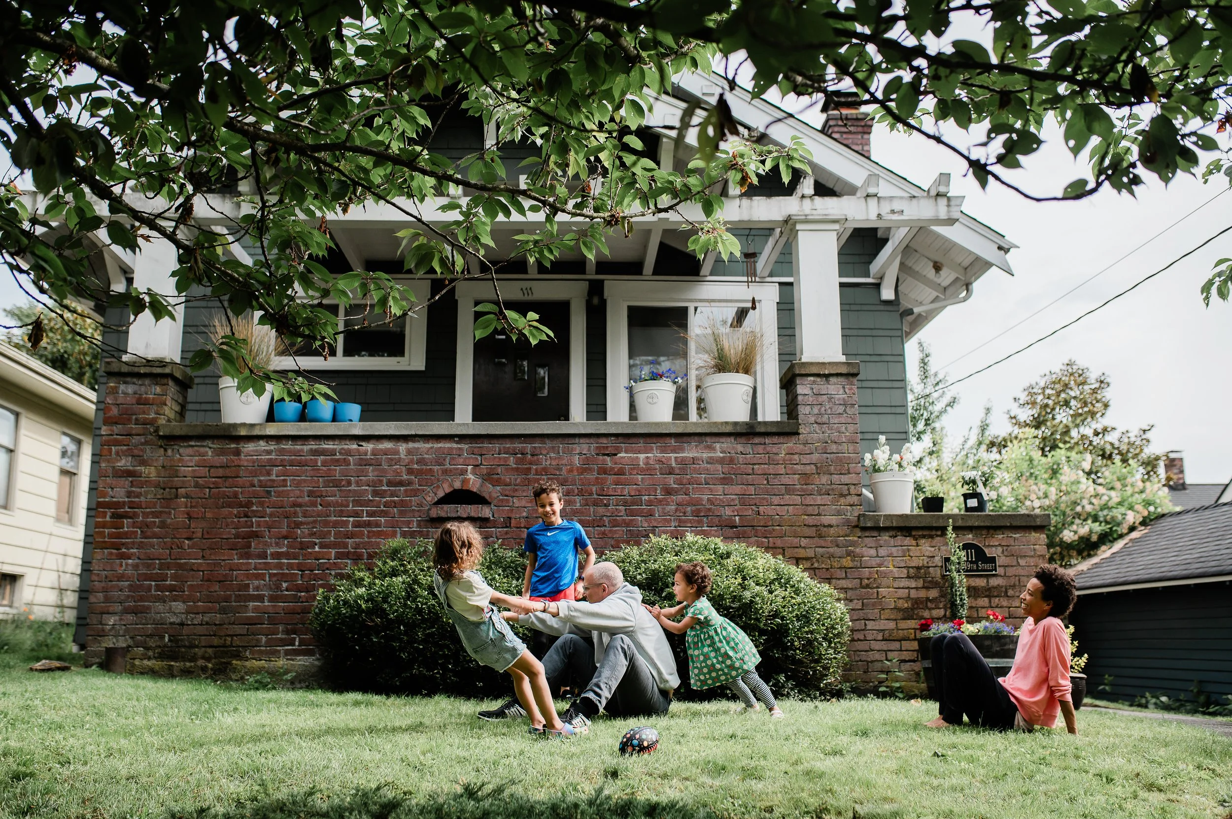 Seattle Family Photographer Anela Deisler - family in their front yard playing.  Kids being silly