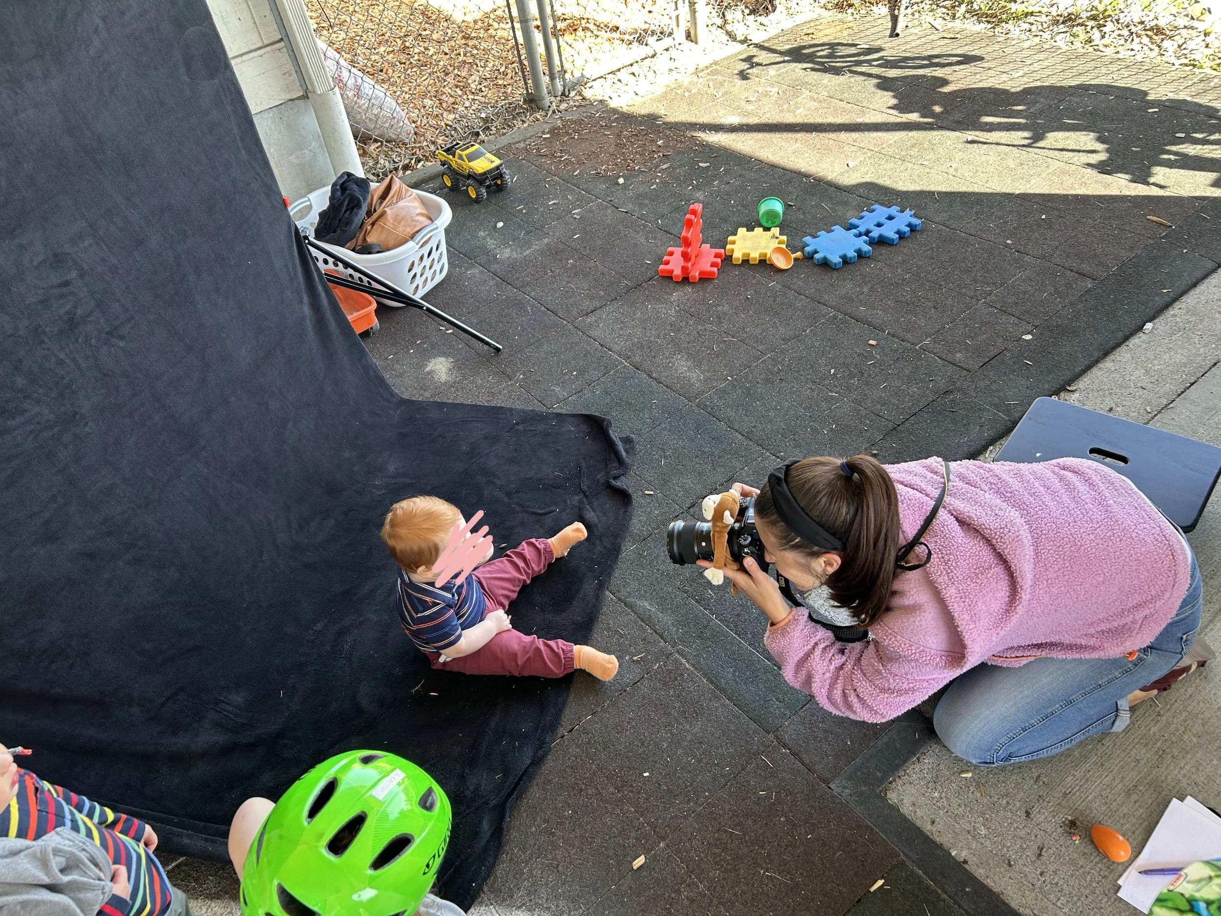 Seattle school photographer interacting with and photographing a sitting baby.