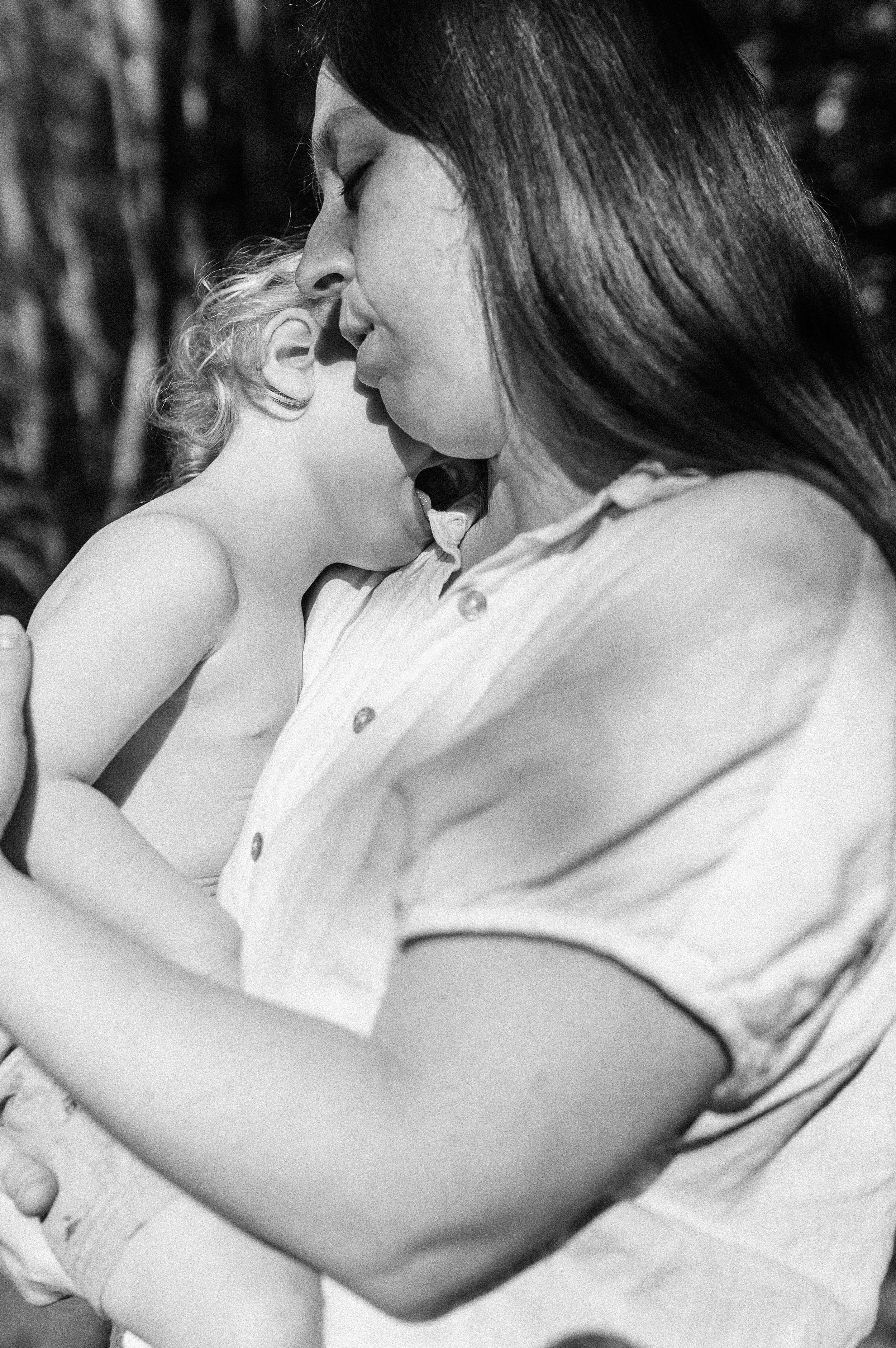 A woman and a child sharing a close, tender moment, with their foreheads touching and eyes closed.