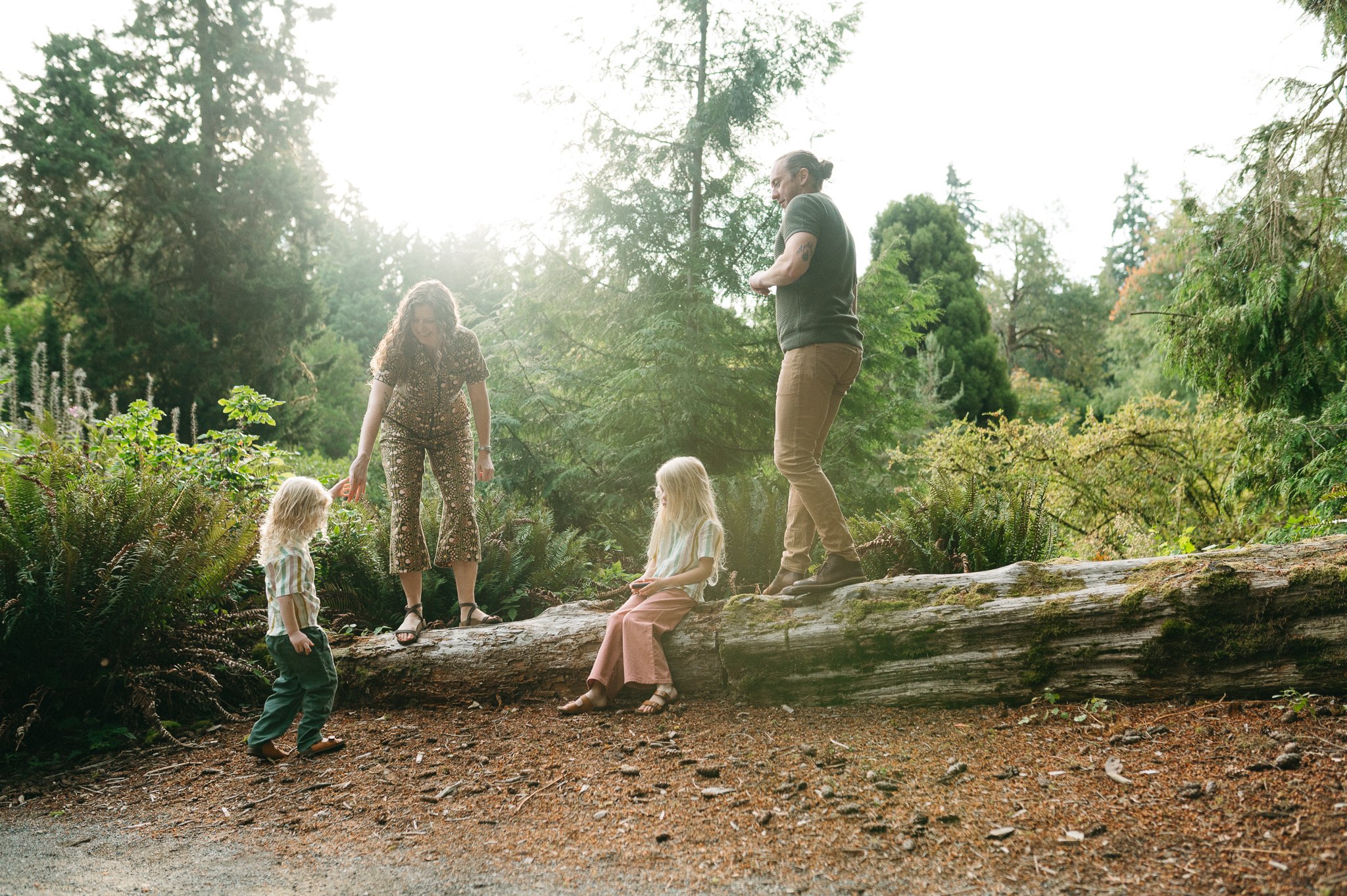 Seattle family walking on a log for a candid holiday card photo