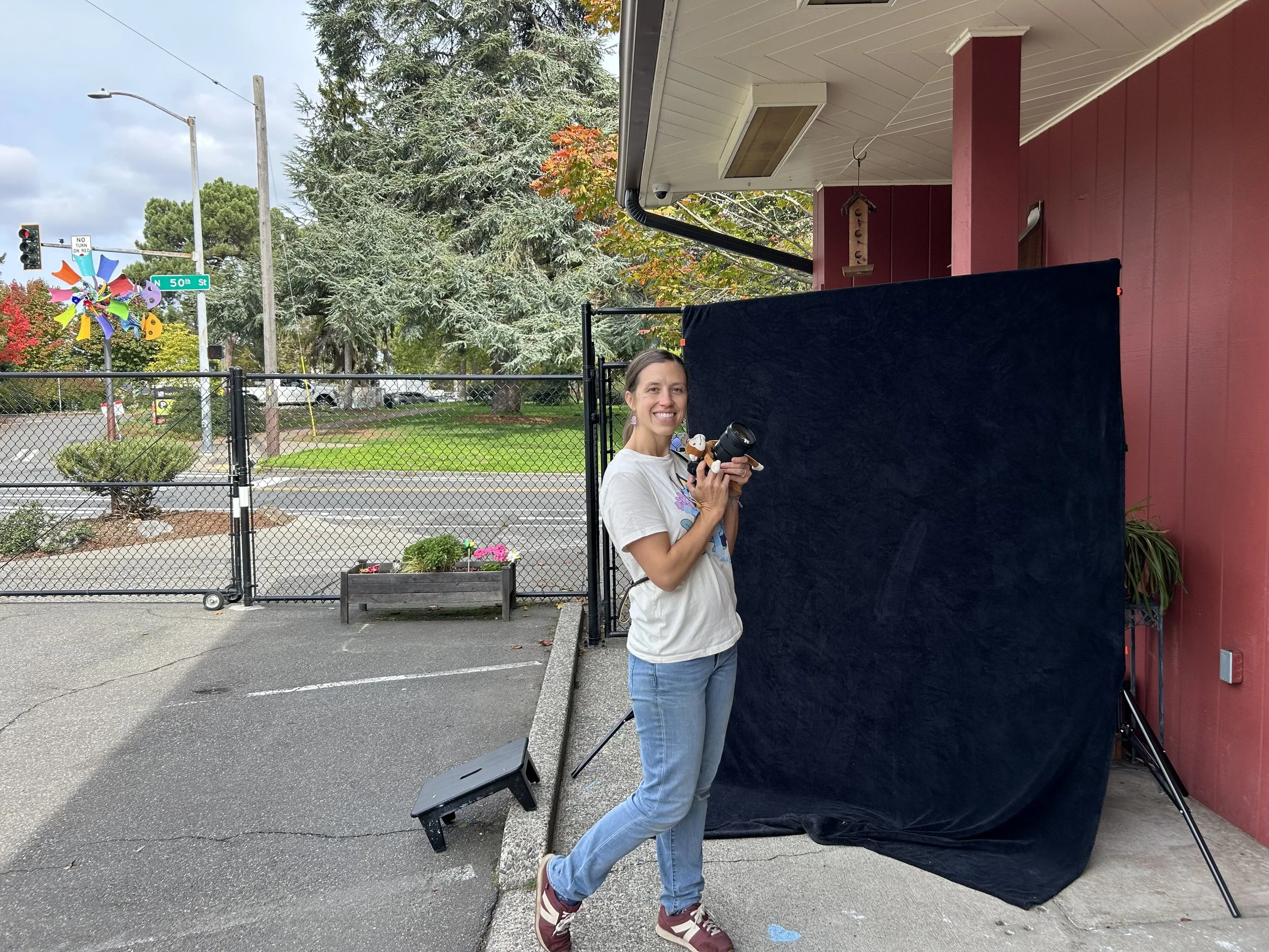 Photographer in front of a simple black backdrop at a seattle school.