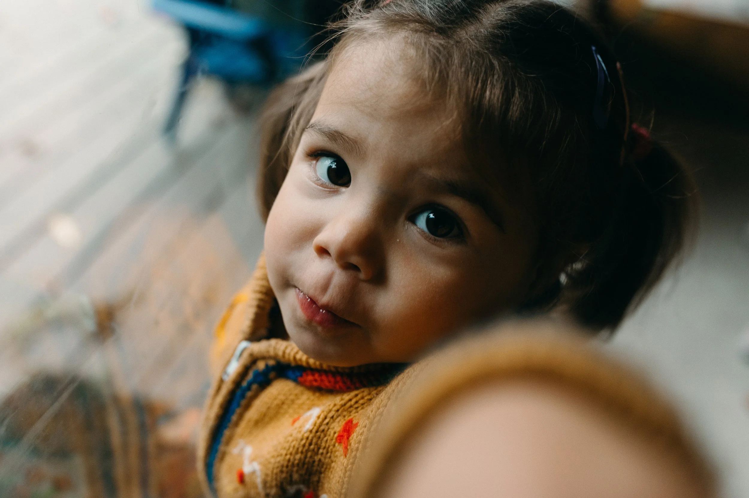 A toddler looks up at you.  toddlers can be tricky to photograph unless you know how to work well with them and their needs.