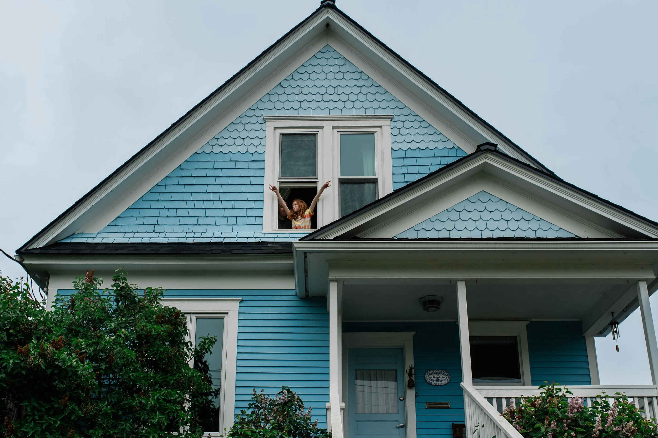 Anela Deisler Seattle Family PHotographer child joyfulling in the window of his home