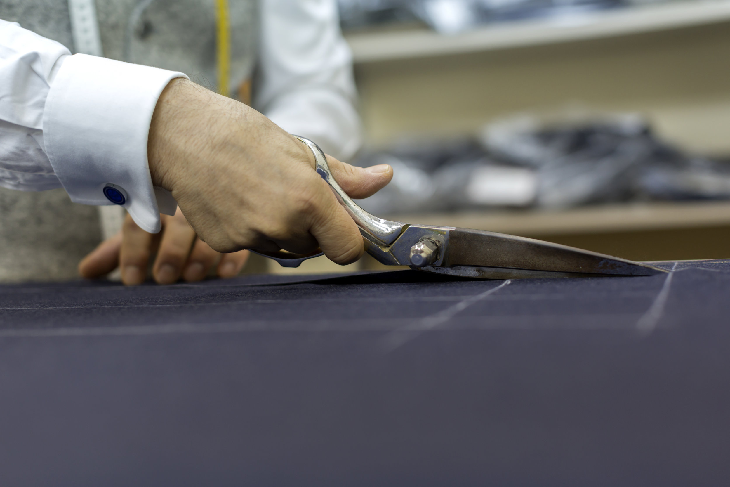 Hands cutting fabric with scissors 