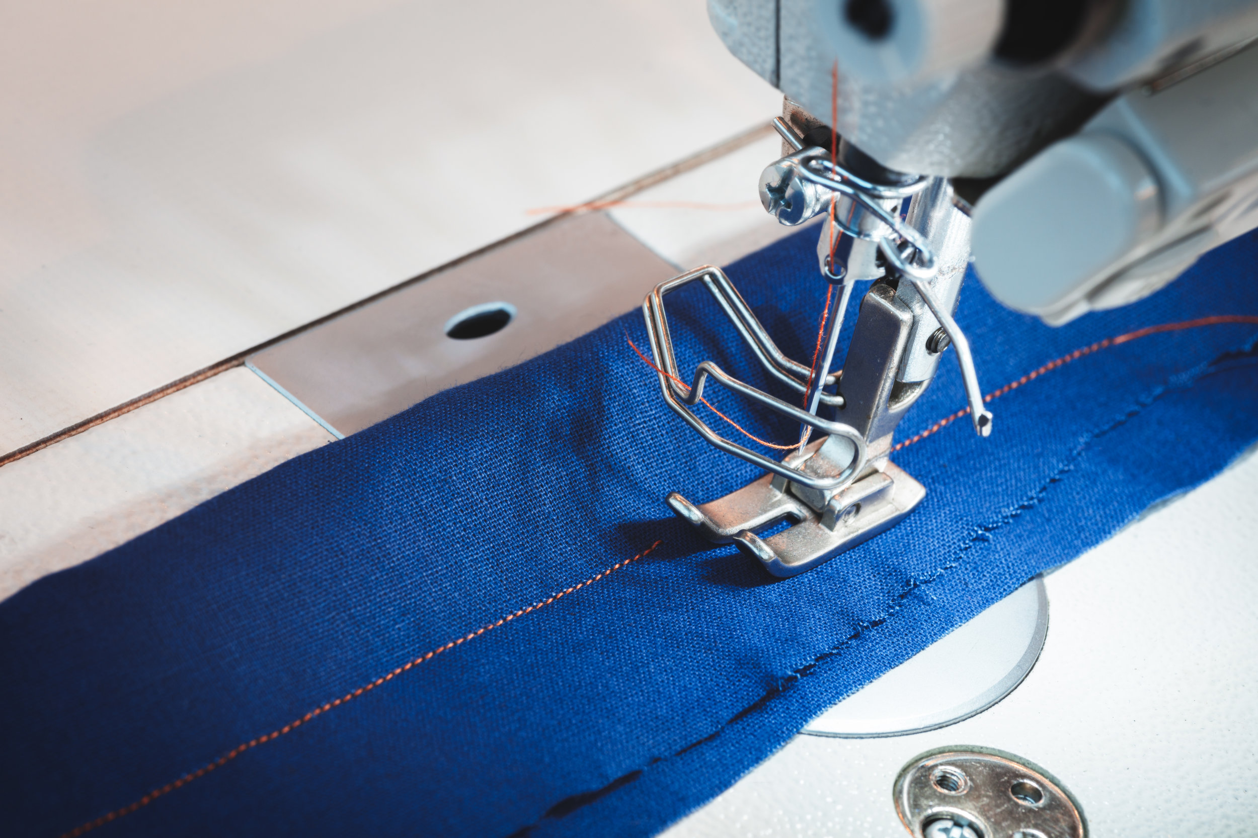 Sewing machine stitching blue fabric