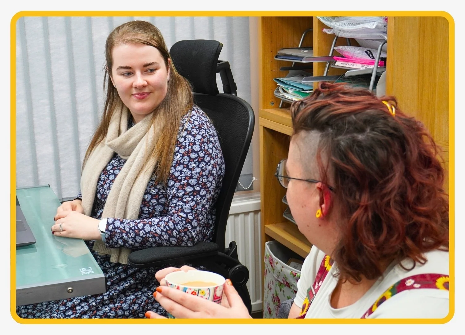 Two speech and language therapists sitting and having a conversation in the Newport Pagnell (Milton Keynes) office.