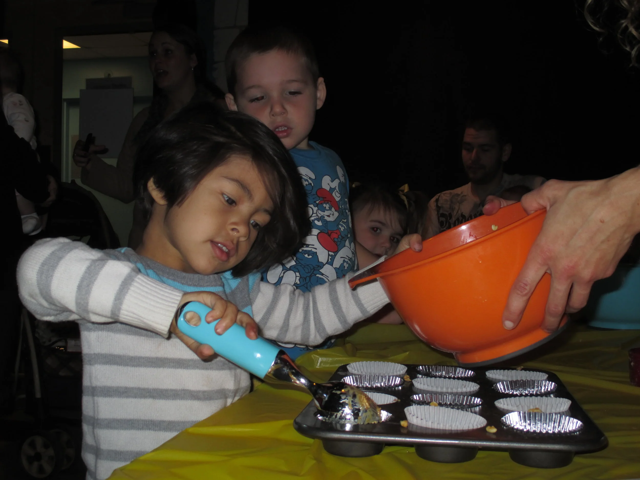 Camps- child scoops batter into cupcake tin.jpg