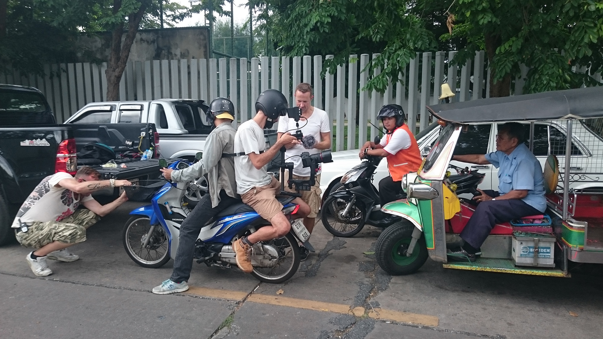 Ziemlich mit viel Risiko; Florian Wyss lässt sich auf das Moped binden, um anschliessend im Verkehr Bangkoks zu filmen...die ganze hilft dabei in den Vorbereitungen.