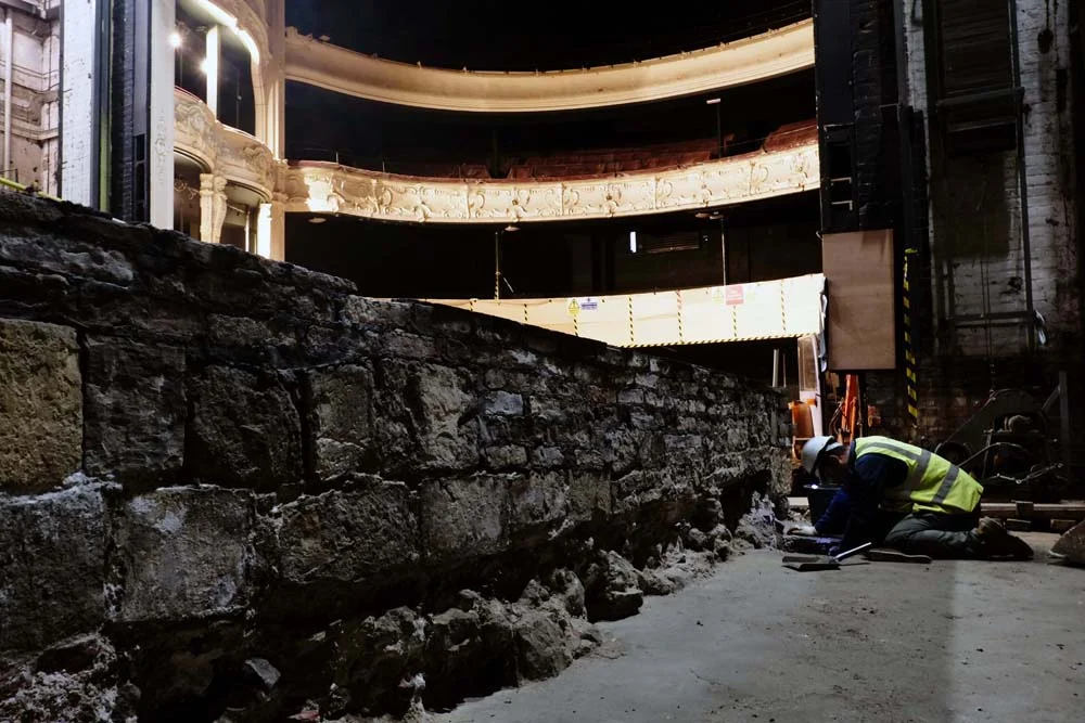 A post-medieval wall which formed the orginsl north external wall of the 1760s theatre and the view up into the dress circle..jpg