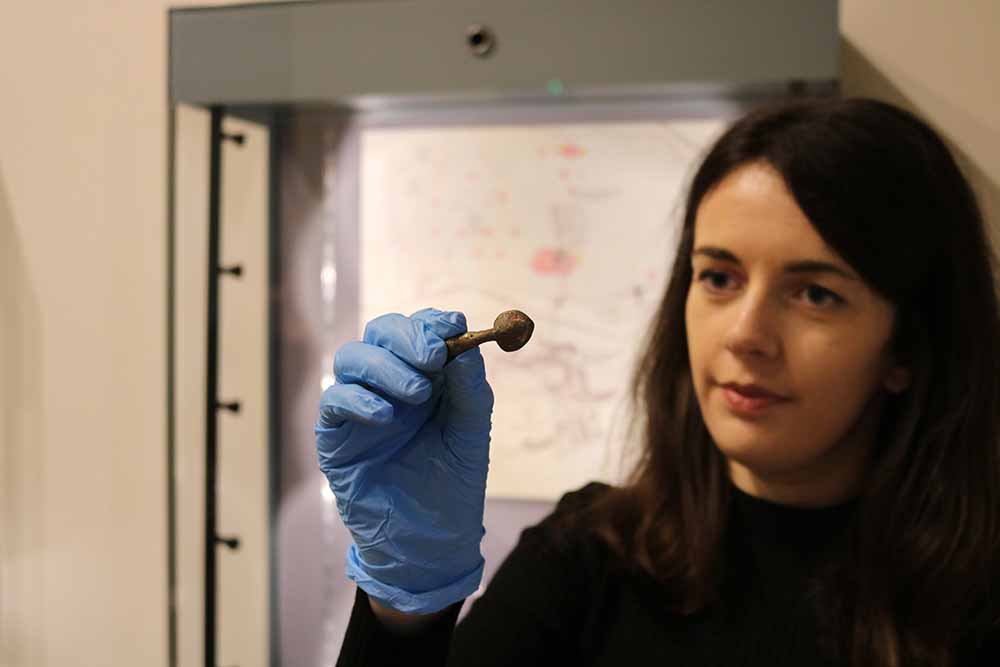 Rebecca Sampson of YAT installing artefacts for the new YourDIG exhibition