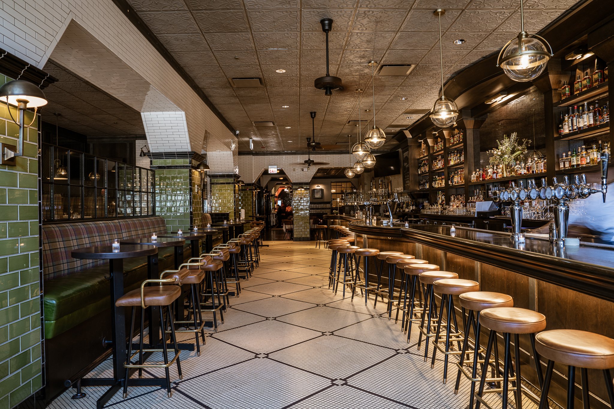 Main bar area view from the entry of The Gage, featuring hightop tables and bar seating.