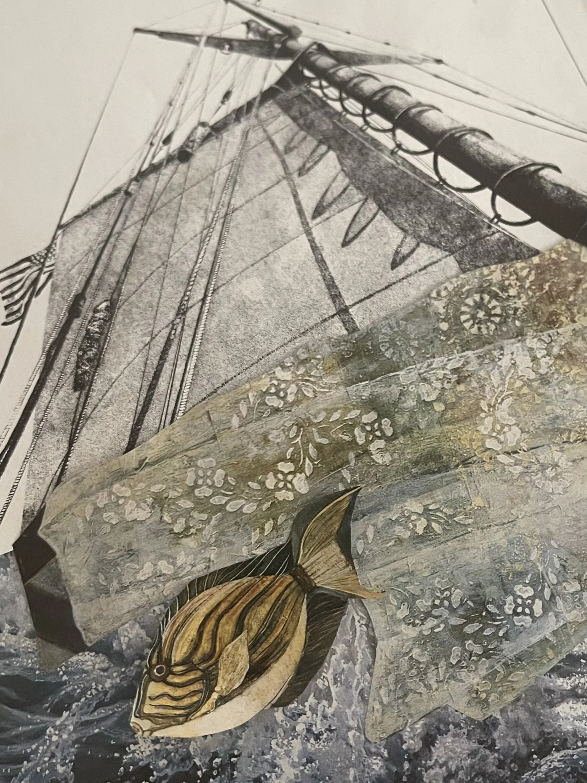 Collage art of a yellow and black fish swimming through choppy waters next to a boat with a white sail and a flower motif-decorated hull. The art is from the fish's vantage point.