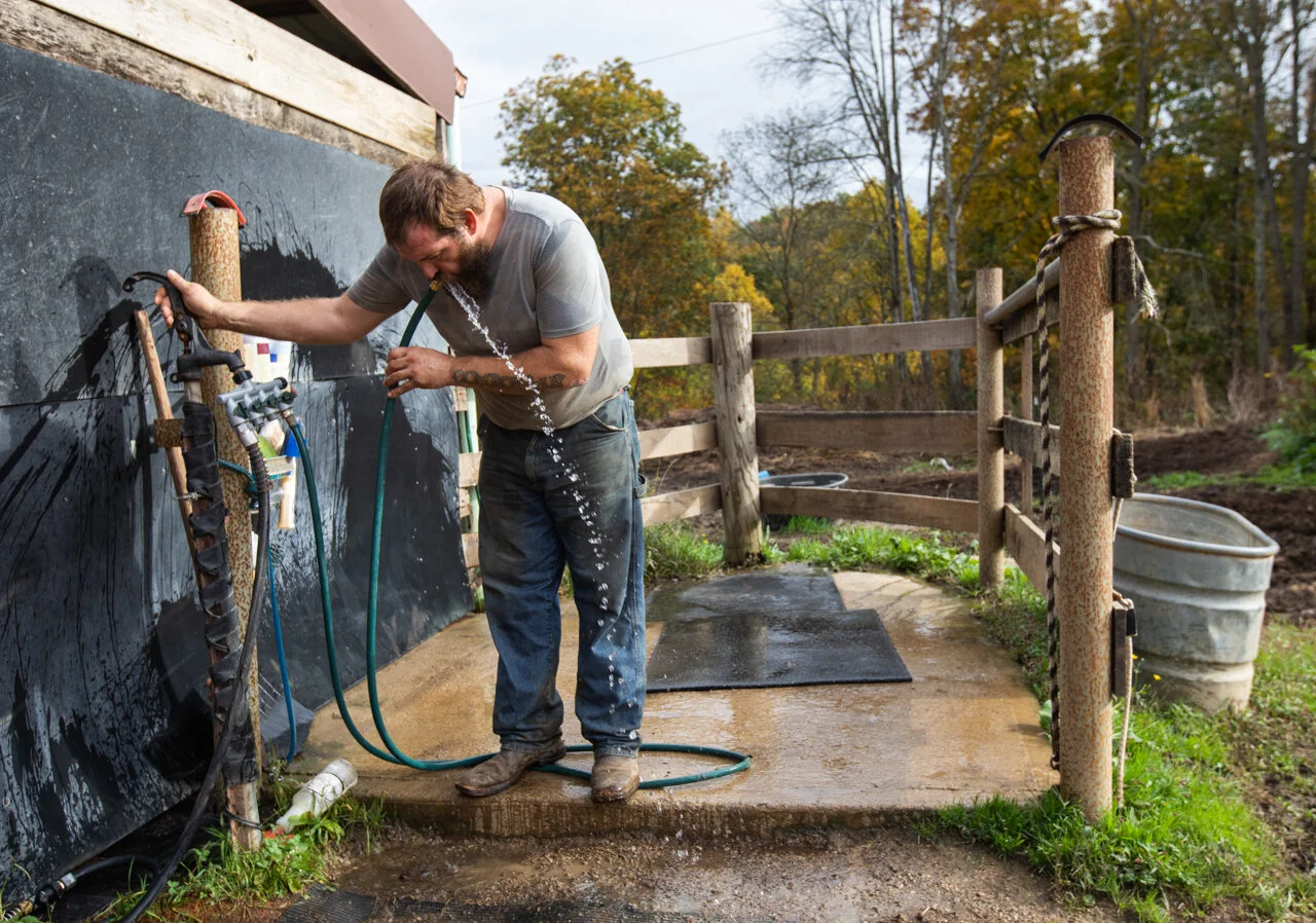  Charlie Musselman drinks from the hose at Smoke Rise Ranch while taking a break after he finished feeding all of the horses inside the main stable on Monday, Oct. 12, 2020. Musselman says while he loves the work there are few days that he doesn't wa