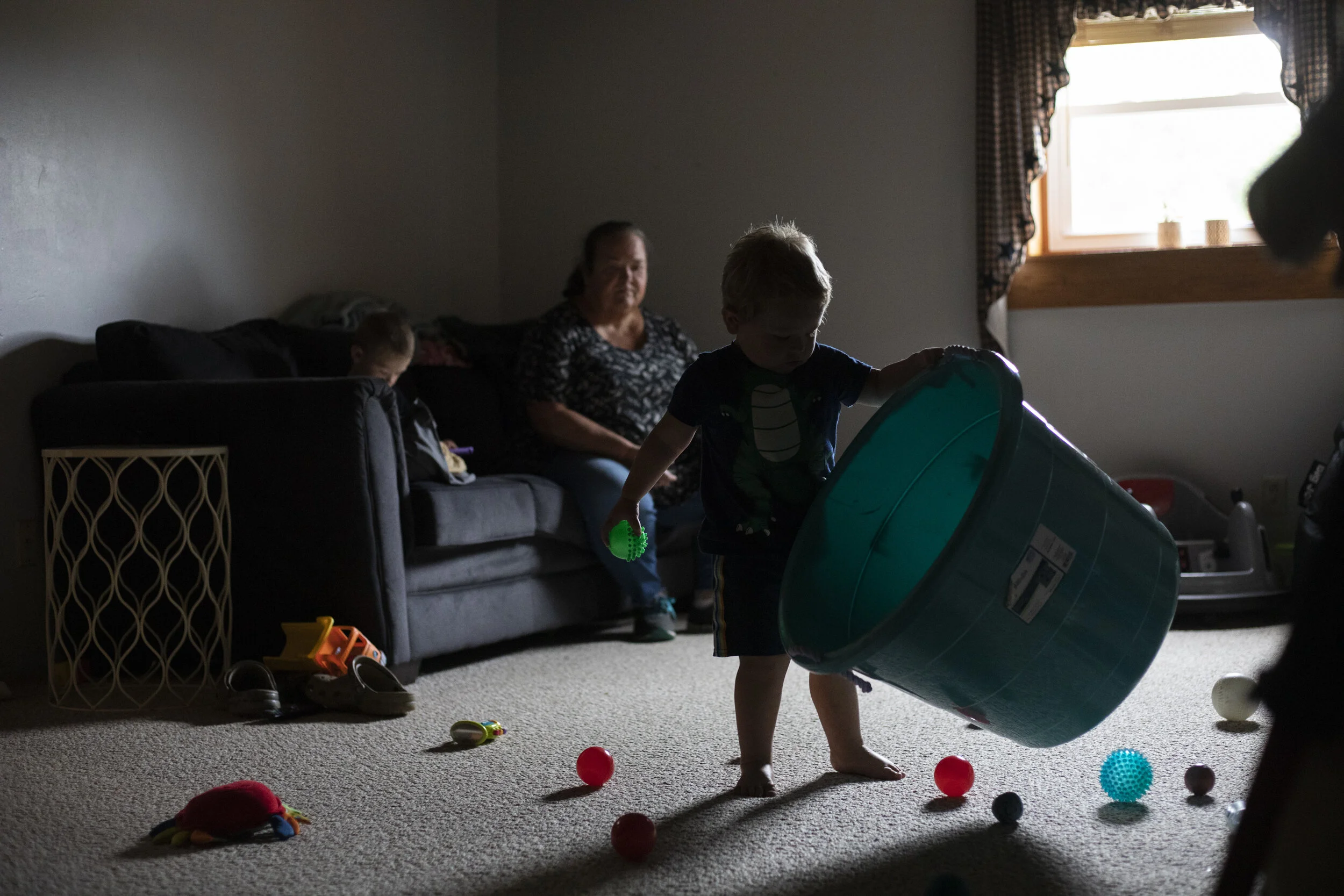  Danita McLaughlin watches as Mangus Shaulis plays in the toy room downstairs while his brother, Silas, watches videos on his tablet on Sept. 24, 2021. "I'm sometimes dead after I leave here," she said 