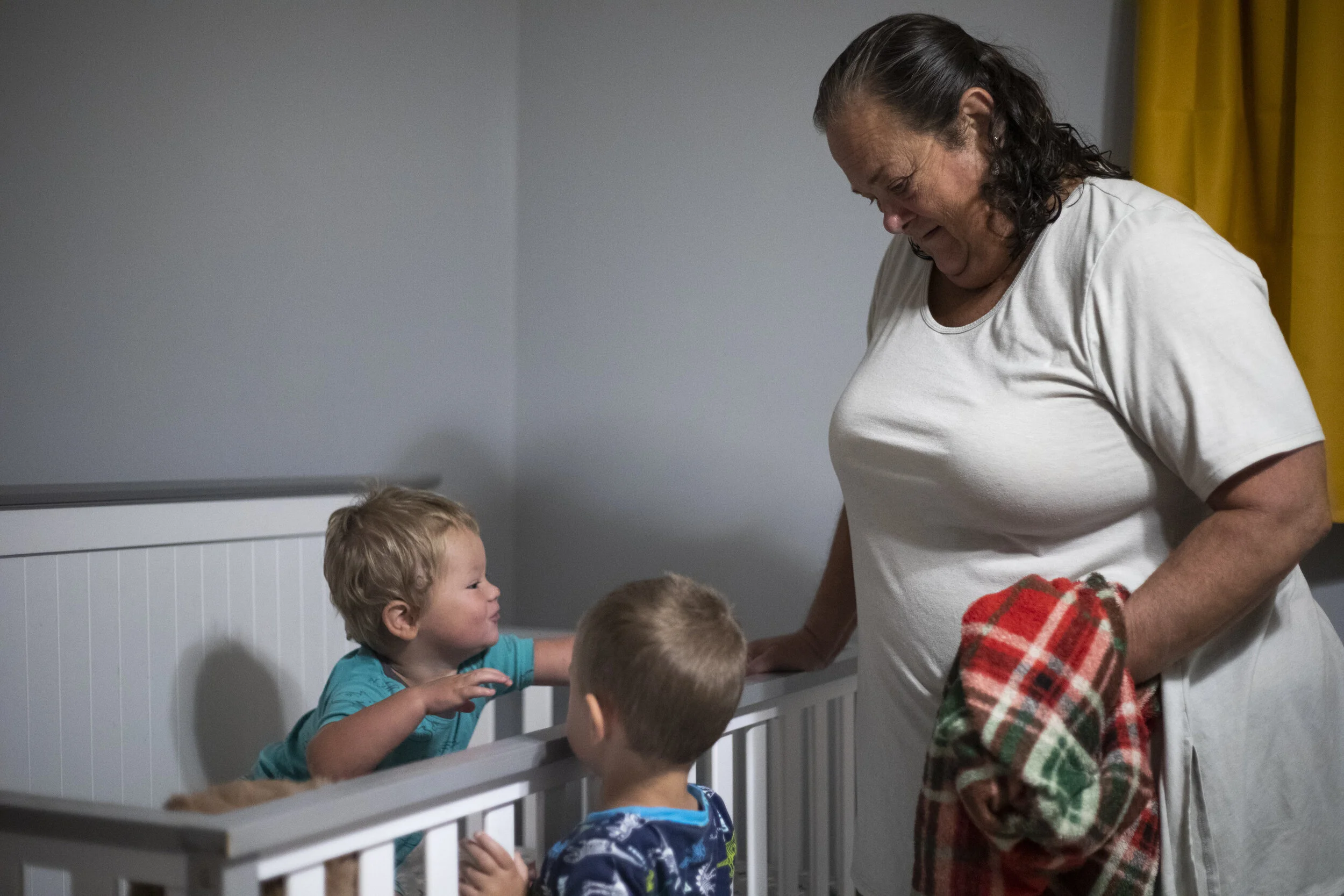  Danita McLaughlin helps Mangus Shaulis, called "Gus" by the family, out of his crib on Sept. 23, 2021. Silas Shaulis ran down the hall and joined them once he heard Mangus start to wake up. Danita normally has a few minutes in the morning to watch t