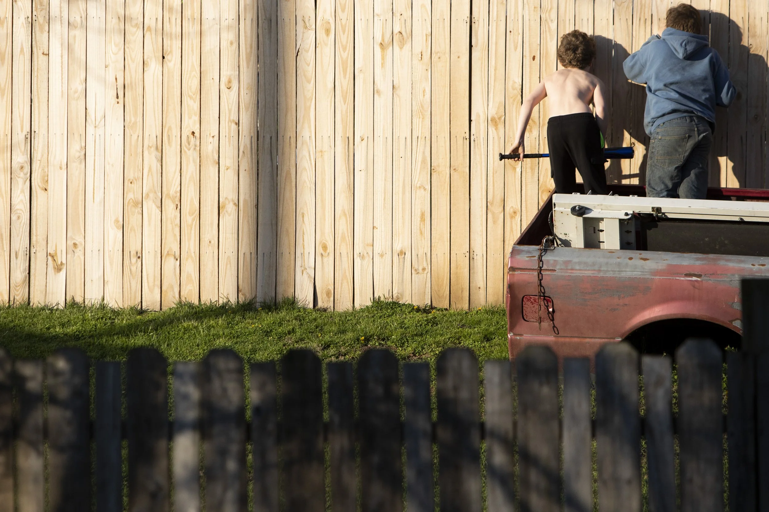  Jeremiah "Miah" McDowell, 9, and Trace Eblin, 11, peer through a fence in the backyard of Miah's grandfather's home in New Marshfield on Sunday, April 4, 2021. 