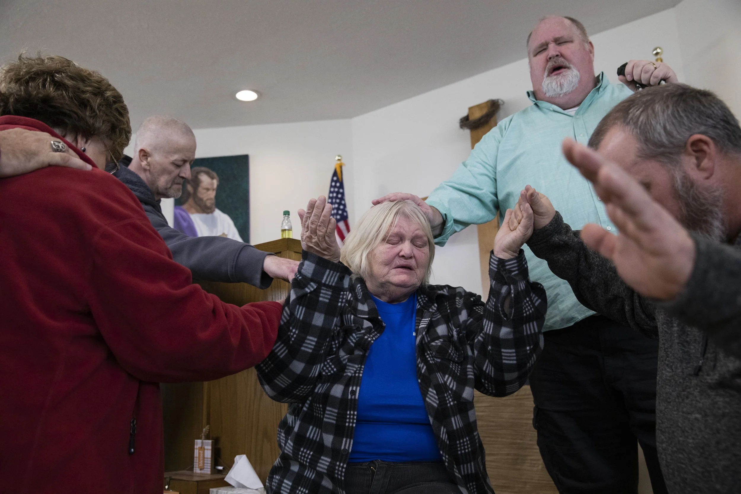  Susan Brooks raises her hands as Pastor Rob Clark places his hand on her head, while the congregation prays for her during the Sunday evening service in Albany, Ohio. Brooks’ nephew had been "saved" — the Christian belief that when someone accepts C