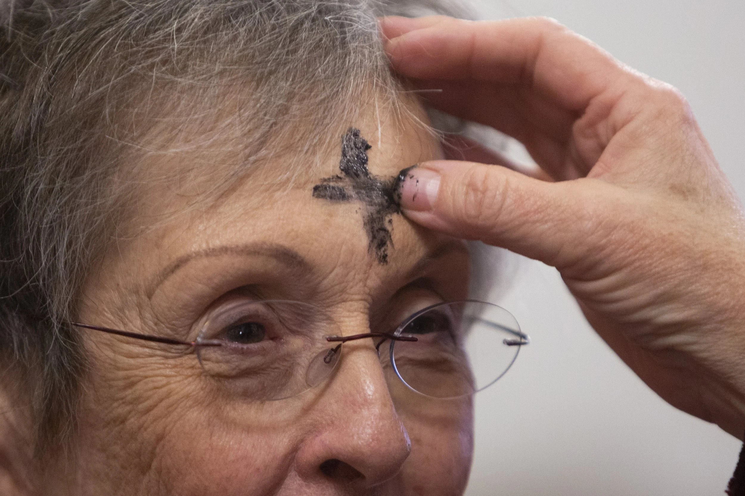  Cindy Hendrix has a cross of ashes drawn on her forehead by Barbara Conover on Ash Wednesday at Alexander Baptist Church outside Athens, Ohio. The church had a small service at 5 p.m. so congregants could receive their ashes before returning home fo