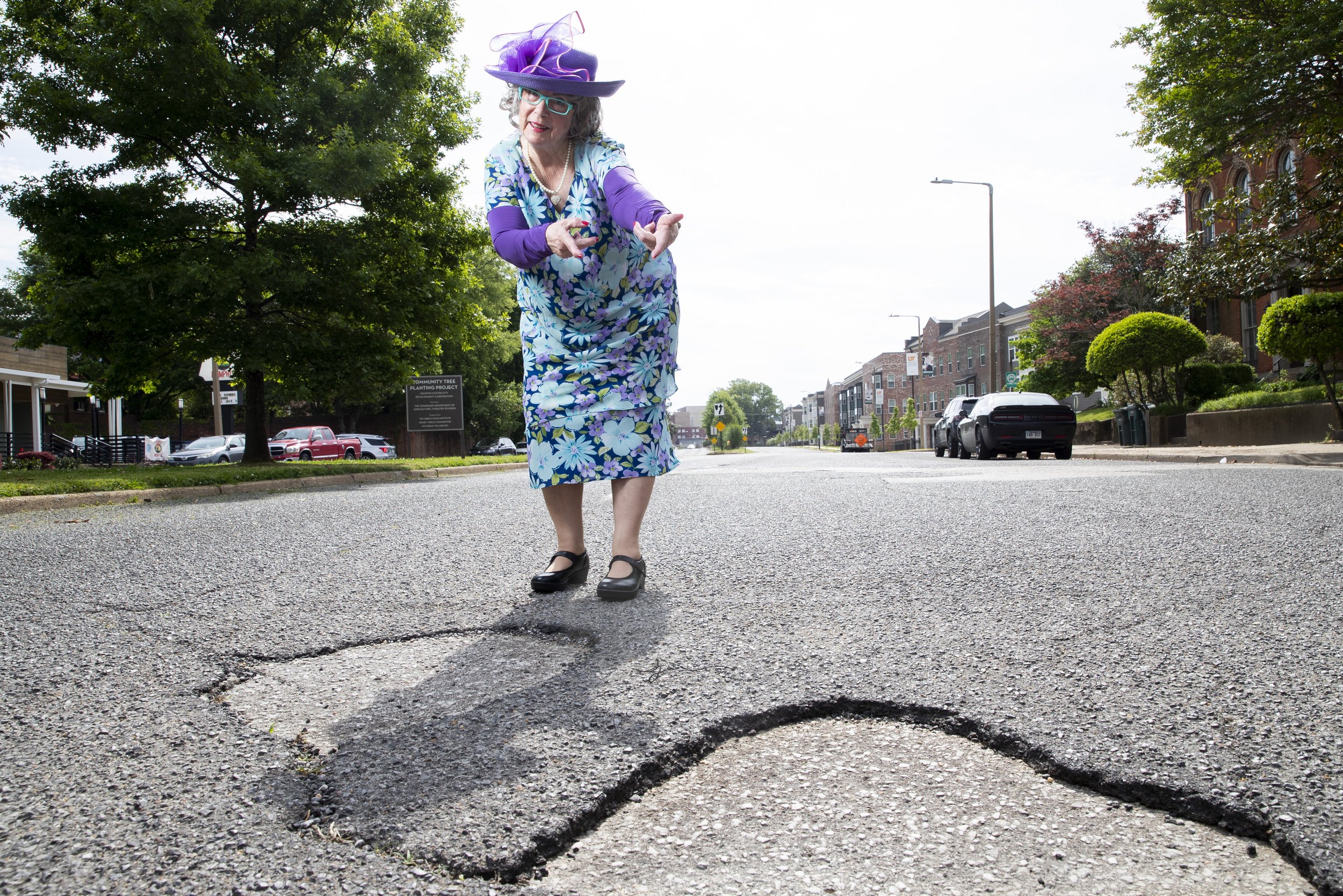 Sybil Presley, known as “The Pothole Lady,” poses for a portrait next to multiple potholes on Jefferson Avenue in Memphis, Tenn., on Friday, April 26, 2024. Presley appeared as this character at a recent Memphis City Council meeting and sang an orig