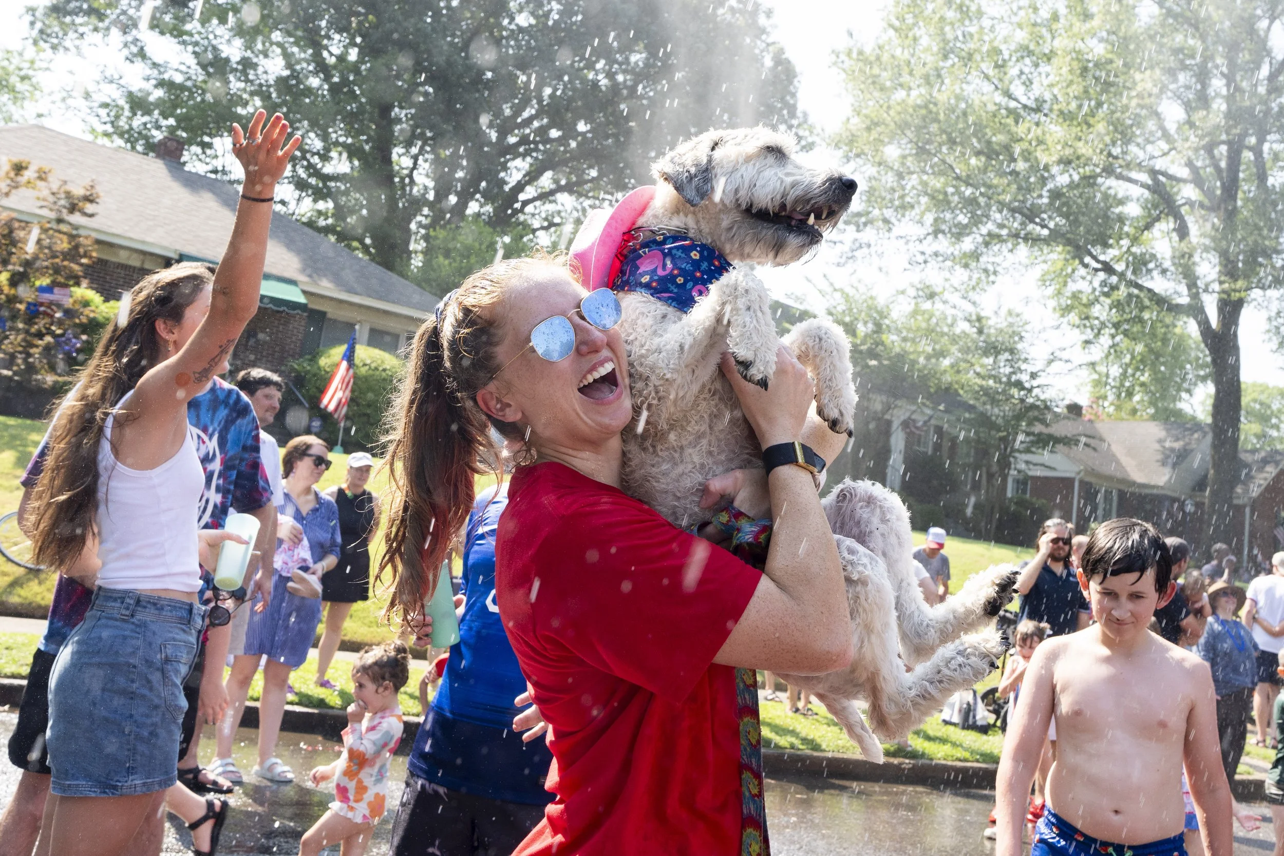  Katelyn Goff holds up Nova Bean, 5, and laughs as they are sprayed by water from a Memphis Fire Department fire truck after the 75th Annual High Point Terrace Neighborhood Independence Day Celebration in Memphis, Tenn., on Thursday, July 4, 2024.  