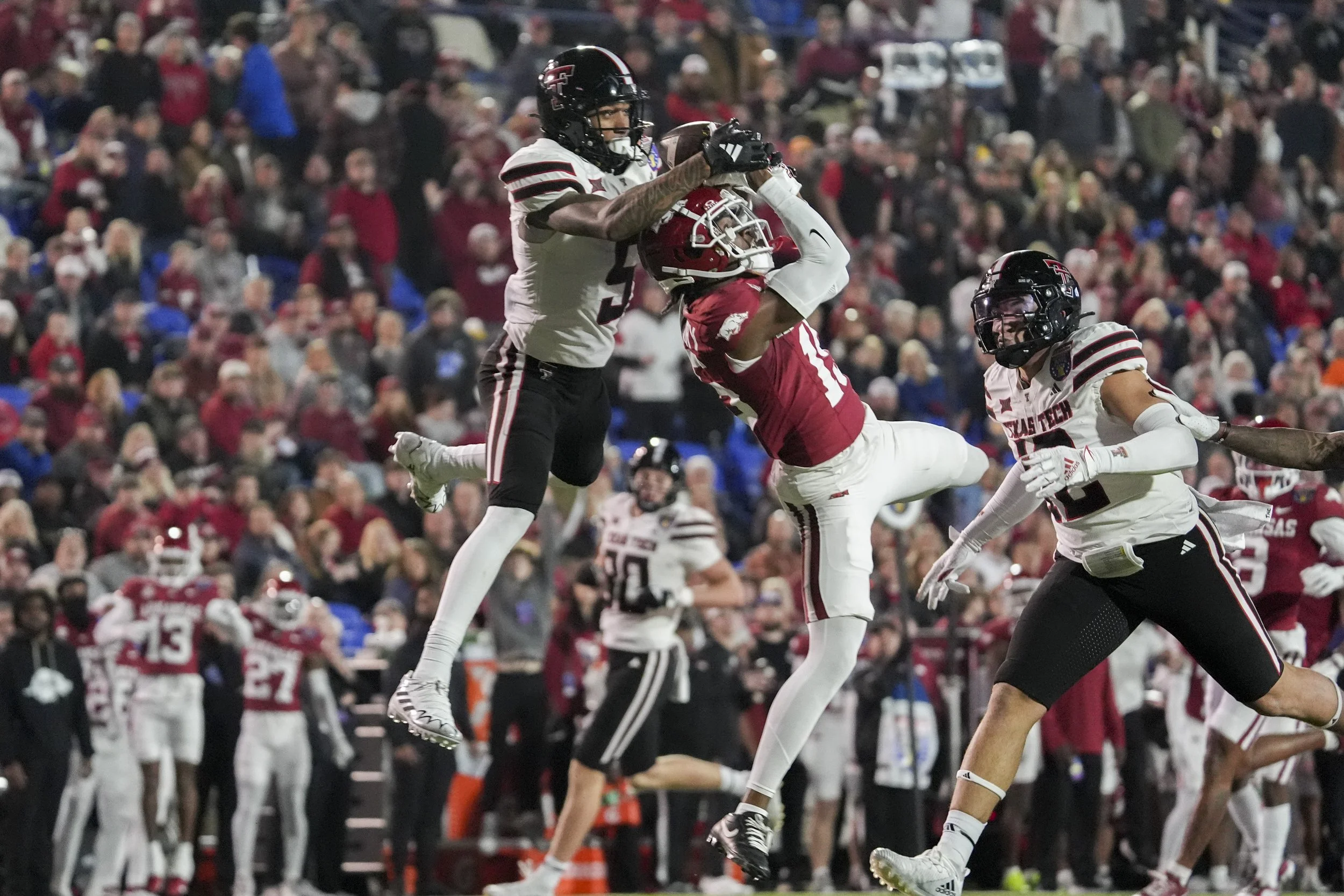  Texas Tech's Caleb Douglas (5) catches a pass over the head of Arkansas' Jaheim Singletary (15) as he goes for the ball during the AutoZone Liberty Bowl between Arkansas and Texas Tech in Memphis, Tenn., on Friday, December 27, 2024.  