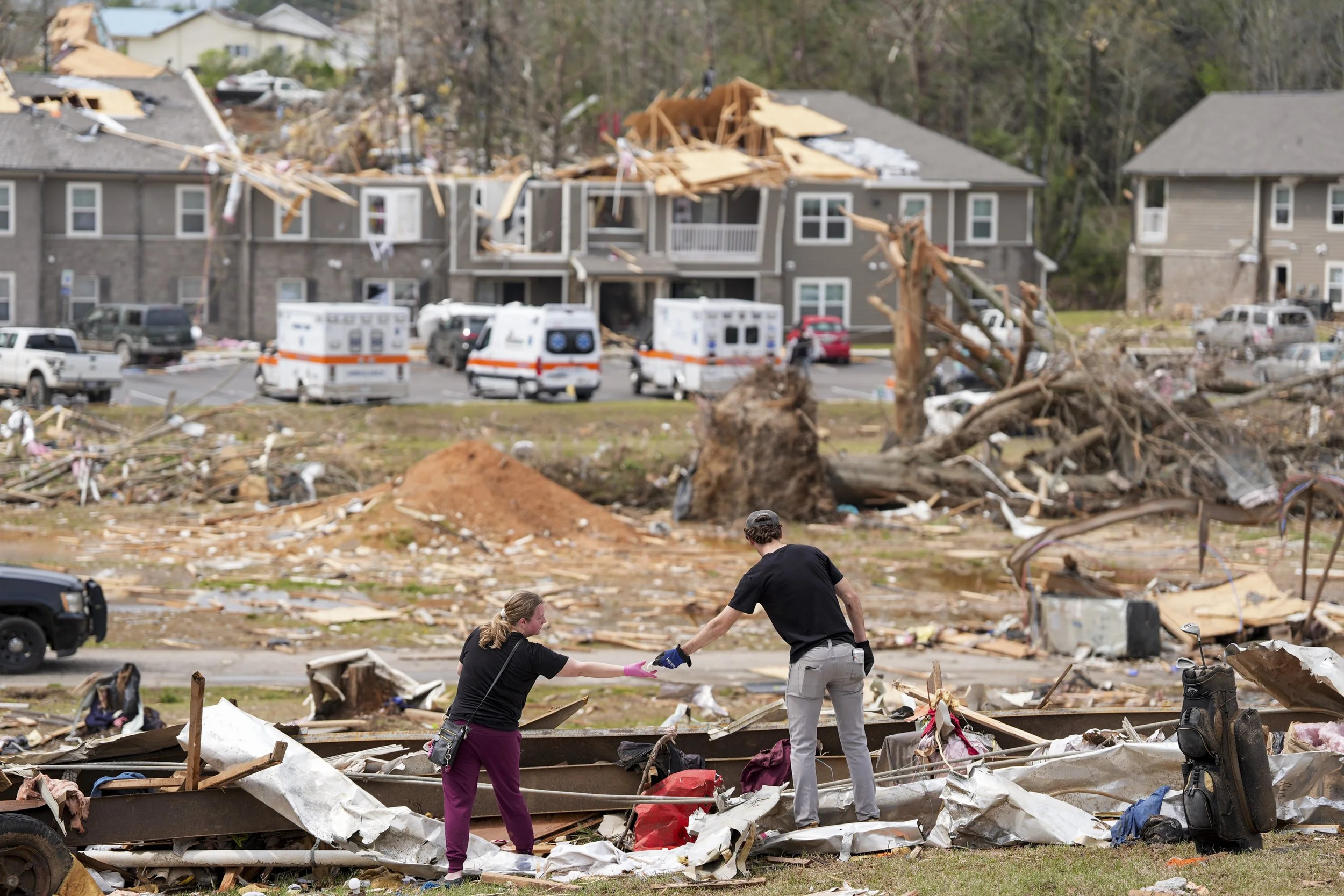  Jesse Furman is handed one of her belongings by Brayden McLemore by a trailer that neighbors her destroyed trailer in Selmer, Tenn., after a suspected tornado tore through the town early Thursday morning on April 3, 2025. Furman and her partner Jose