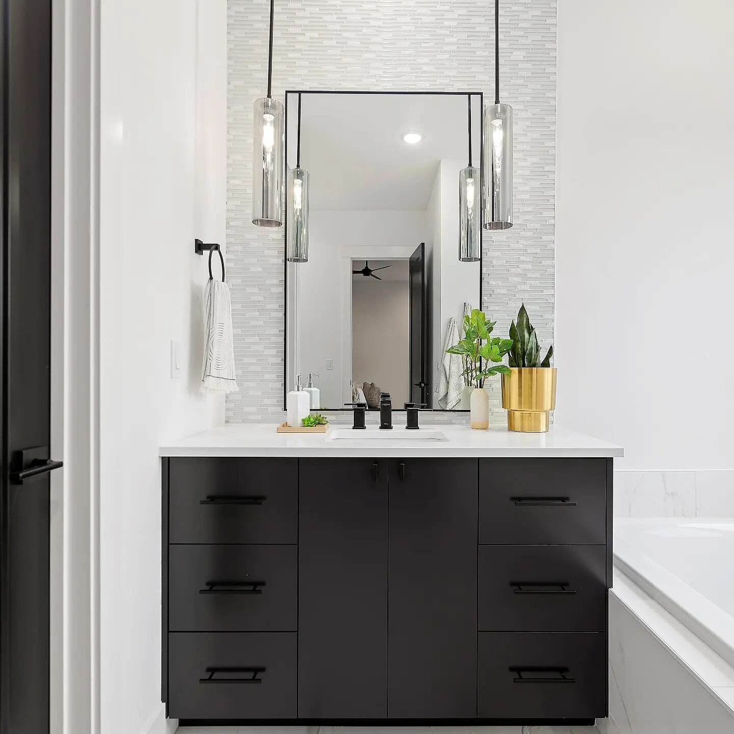 Loving the smoke glass pendant lights, tile backsplash to the ceiling and accent mirror in this primary bathroom. ✨️
.
.
.
.🔨 Design &amp; Build @customhomesbb
. 🛋 Home Decor @sullivanhomesstaging
. 📷 Photography @sunnyskiesmedia
.
.
.
.
.
#interi