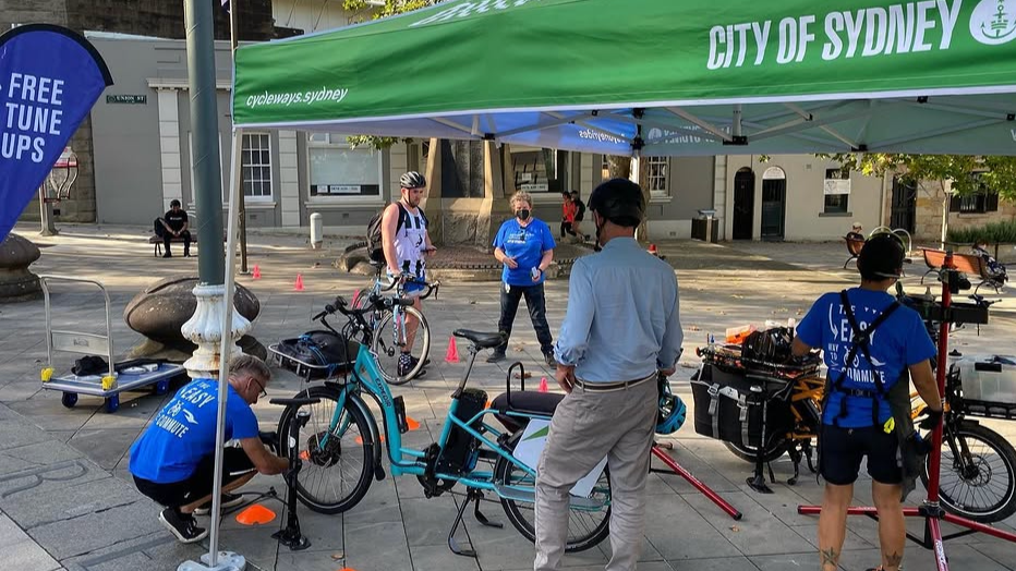 Three Pedal Set Go bike educators at Union Square providing bike advice and tune-ups as part of the City of Sydney Share the Path program.