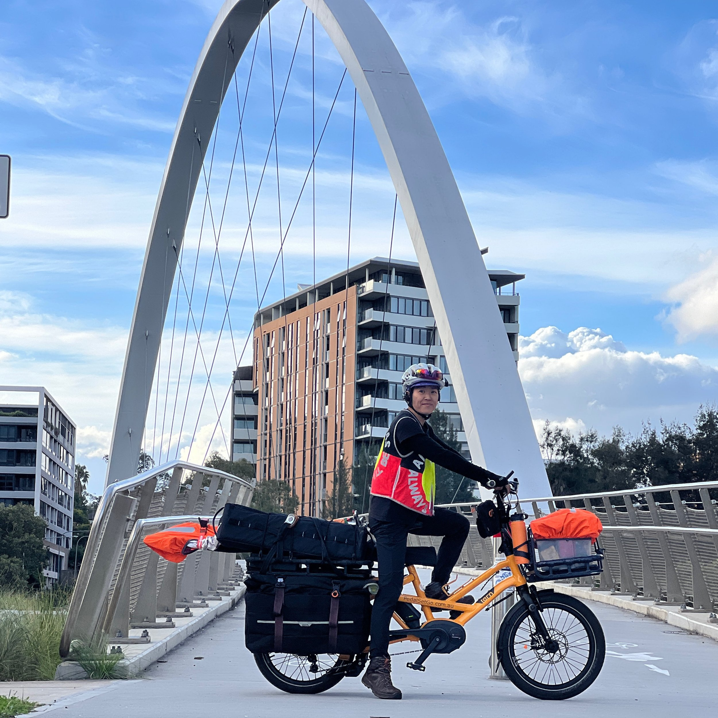 Instructor riding a loaded Tern GSD long-tail cargo bike across a bridge in Parramatta, demonstrating confident cargo handling.