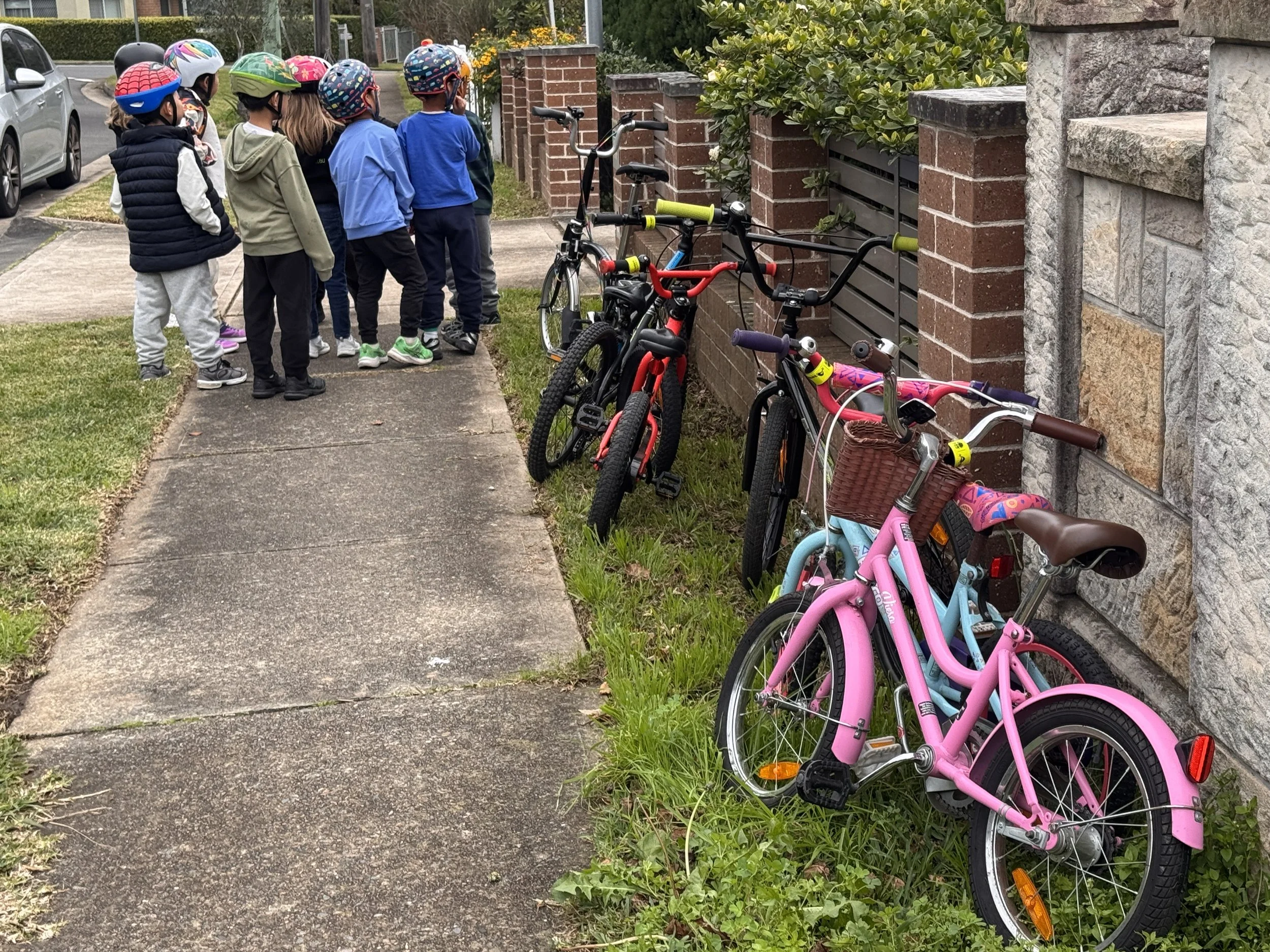 Children with instructor from Pedal Set Go learning about observation and decision making on street where shared path intersects a driveway.