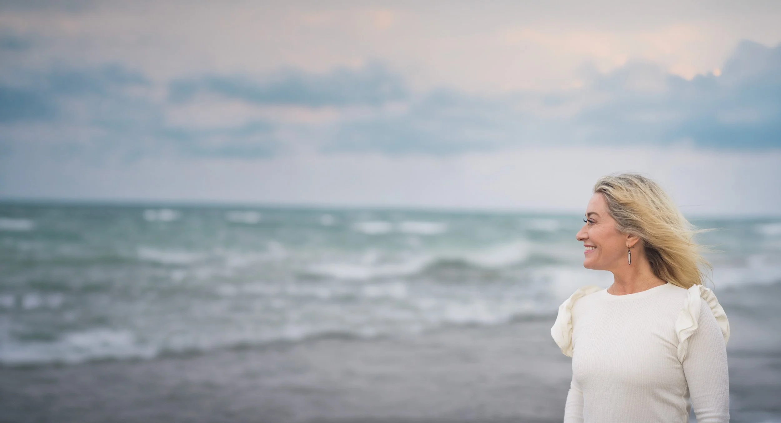 Anna Marcolin, Illinois-based life coach and therapist, smiling and looking out at the sea