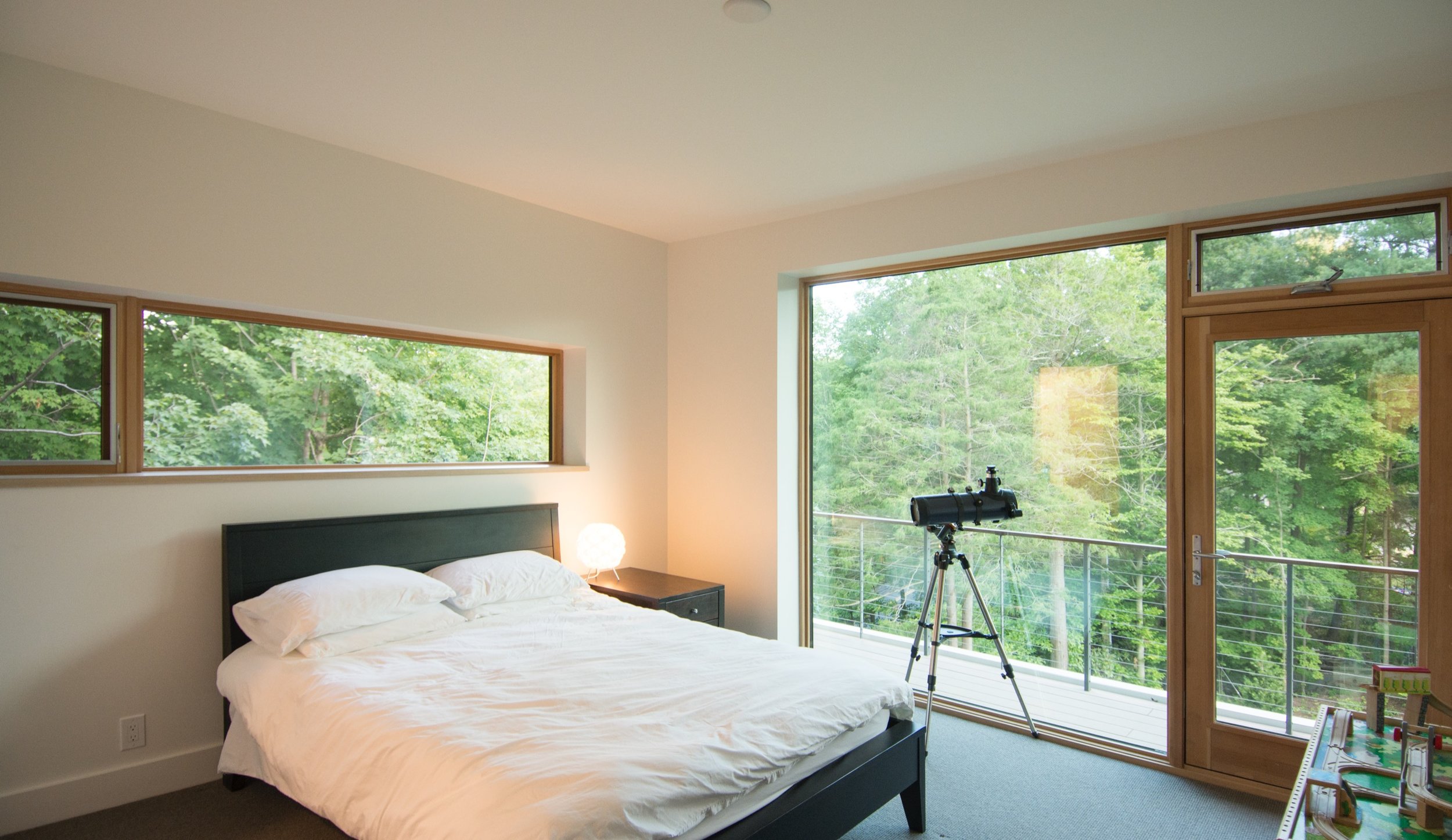 Bedroom with balcony and views into trees