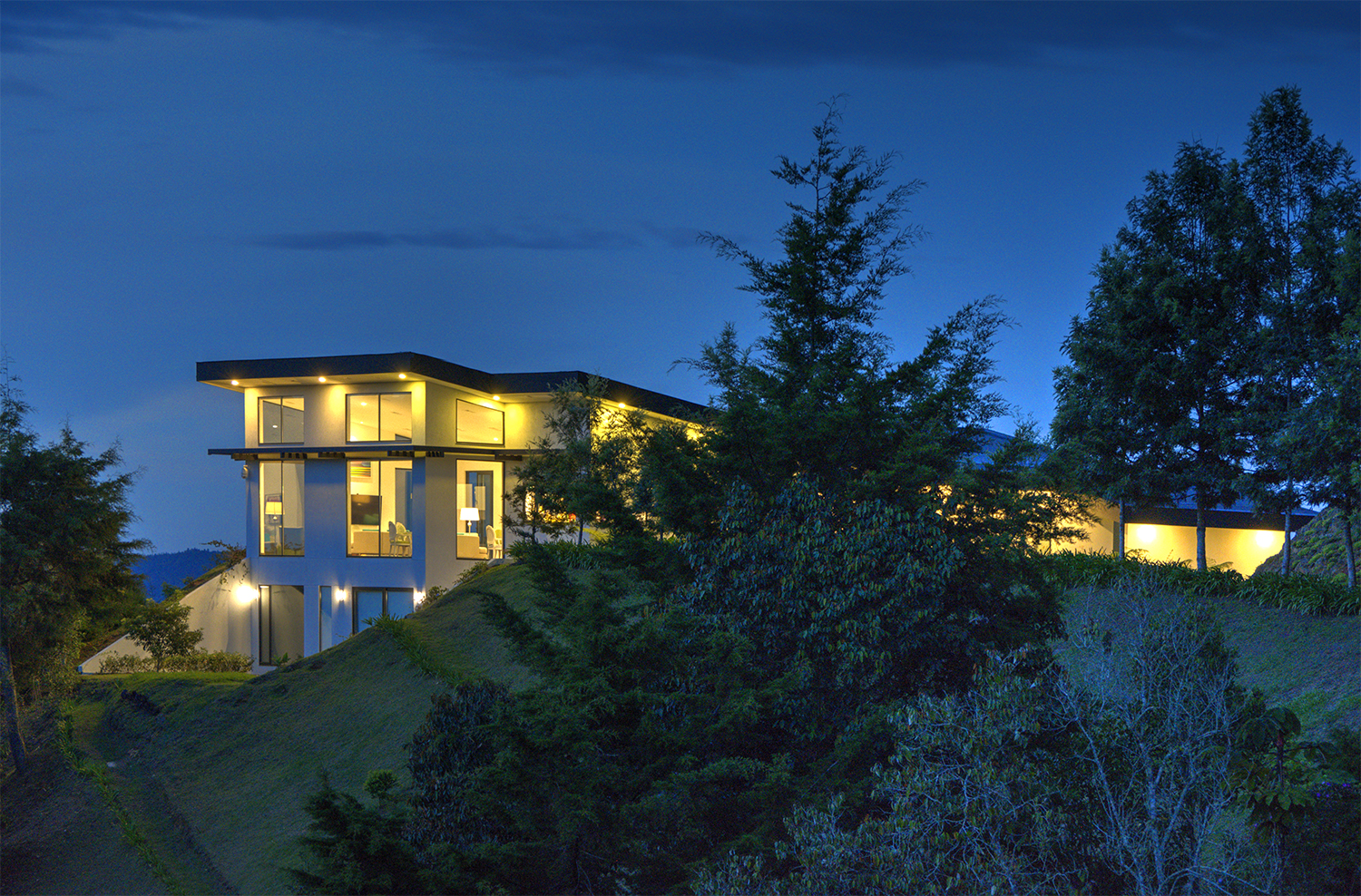 View of house at night from surrounding landscape