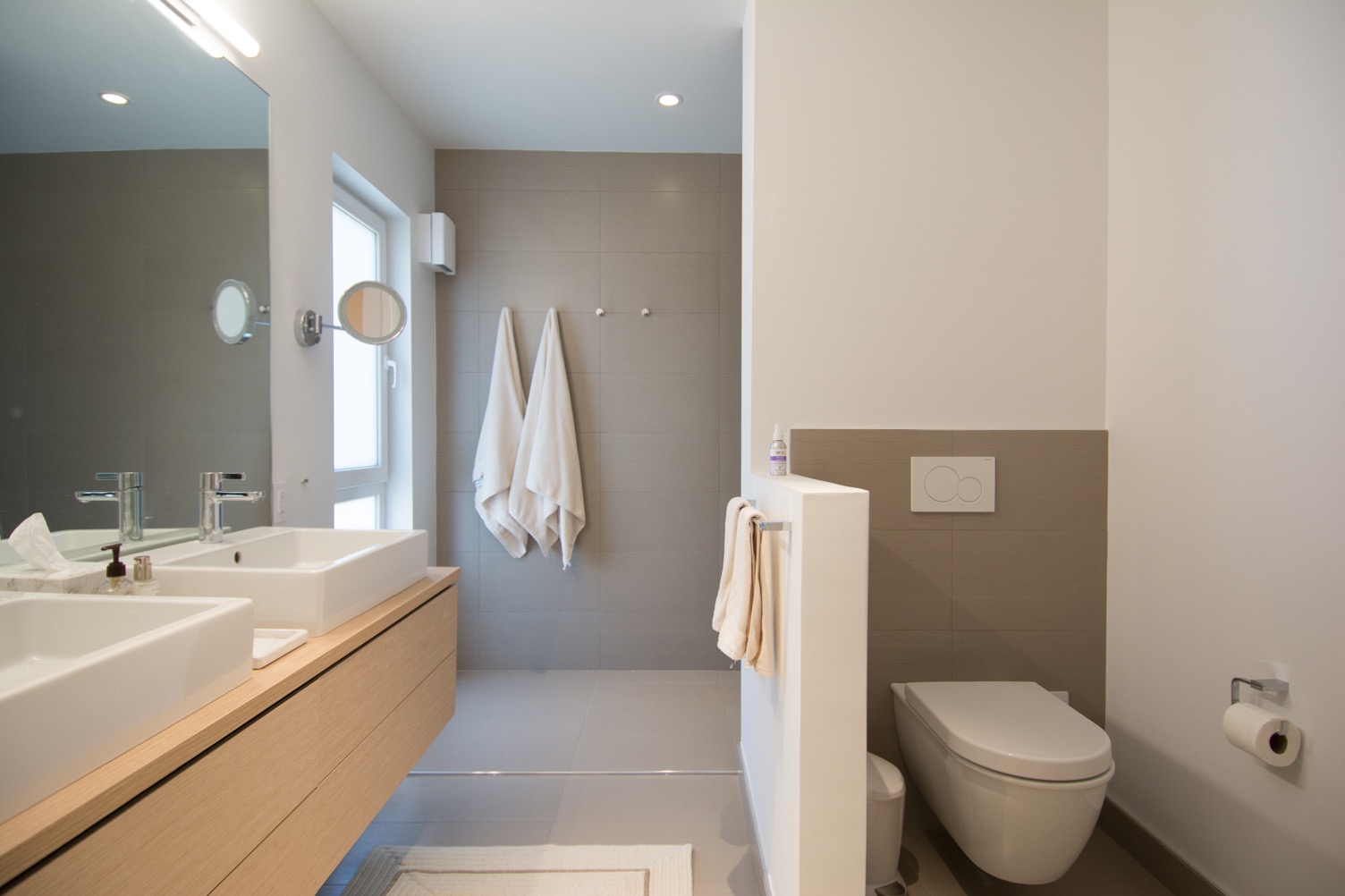 Modern bathroom with double vanity and wall hung toilet