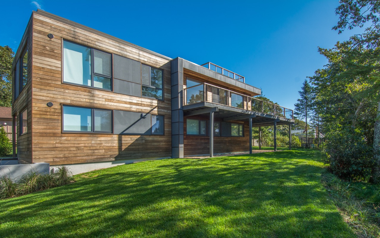 Exterior view of house with lawn and main floor deck