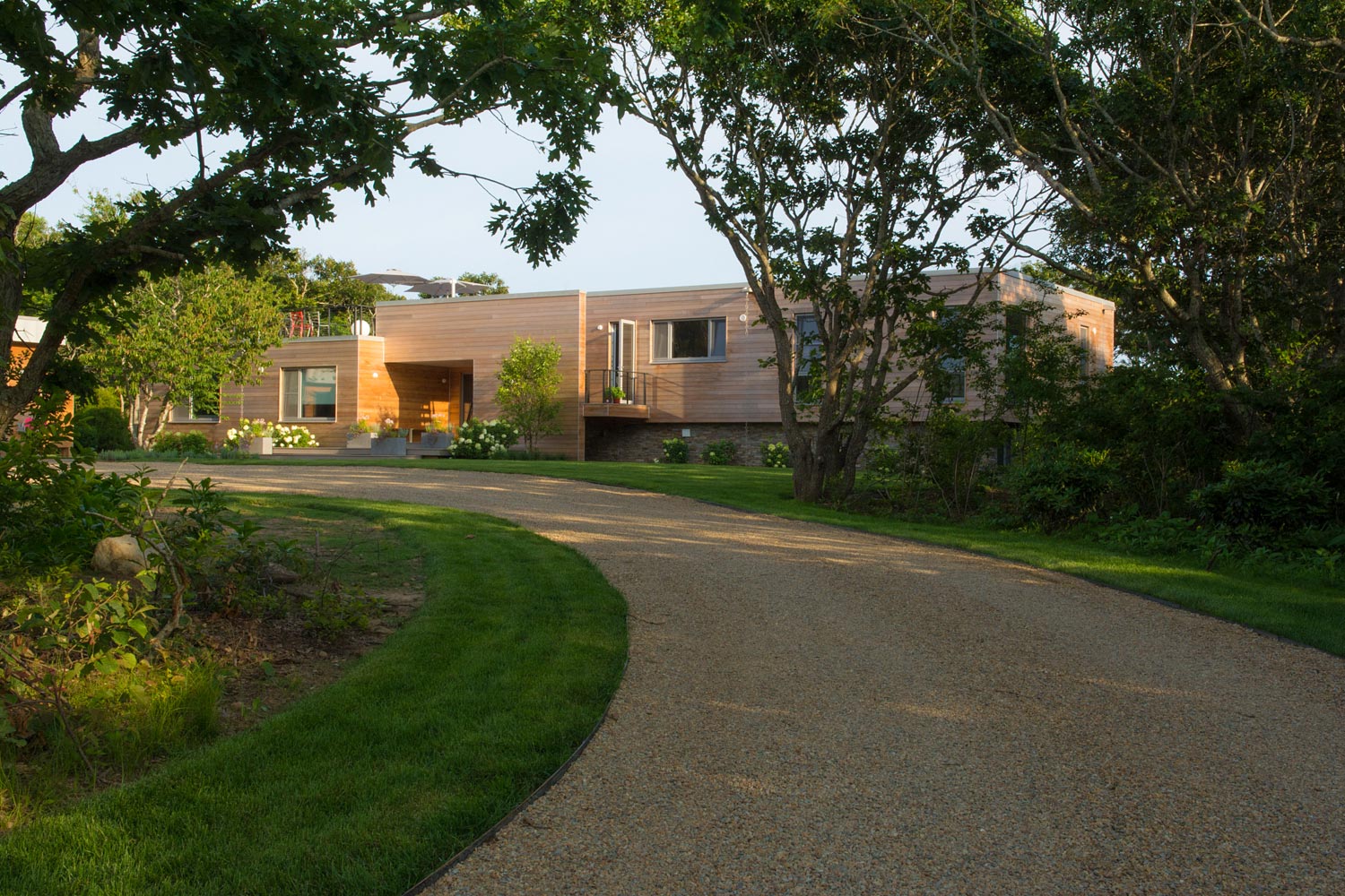 View of beach house from driveway through trees