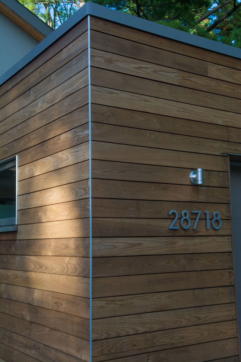 Corner of garage with exterior light fixture and street numbers