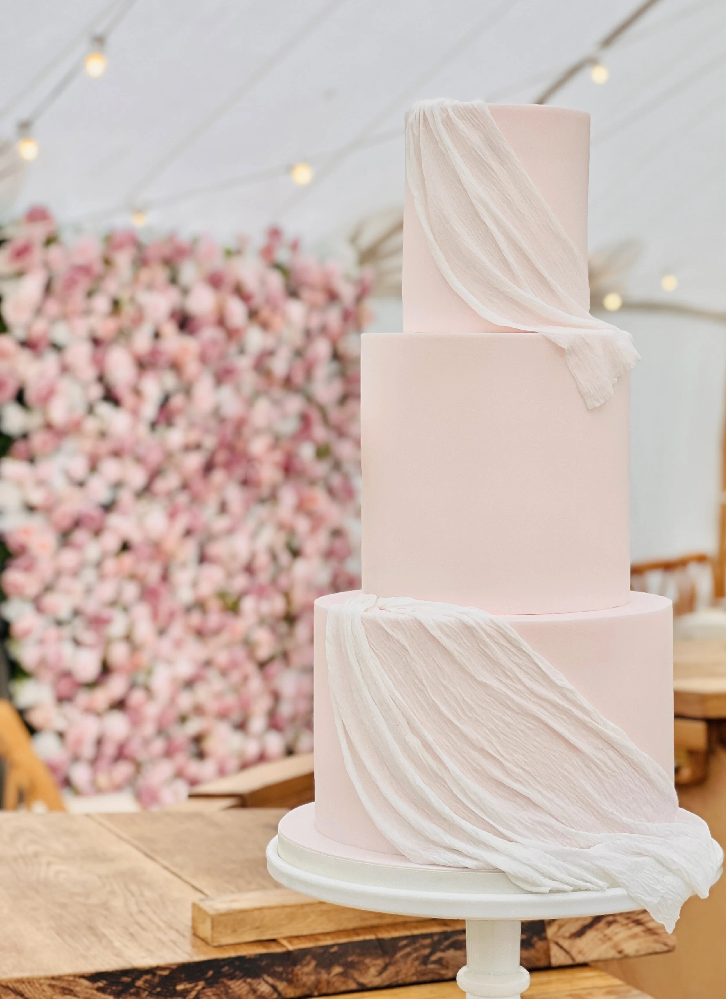 3 tier blush pink wedding cake with sheer wafer fabric draping.jpeg