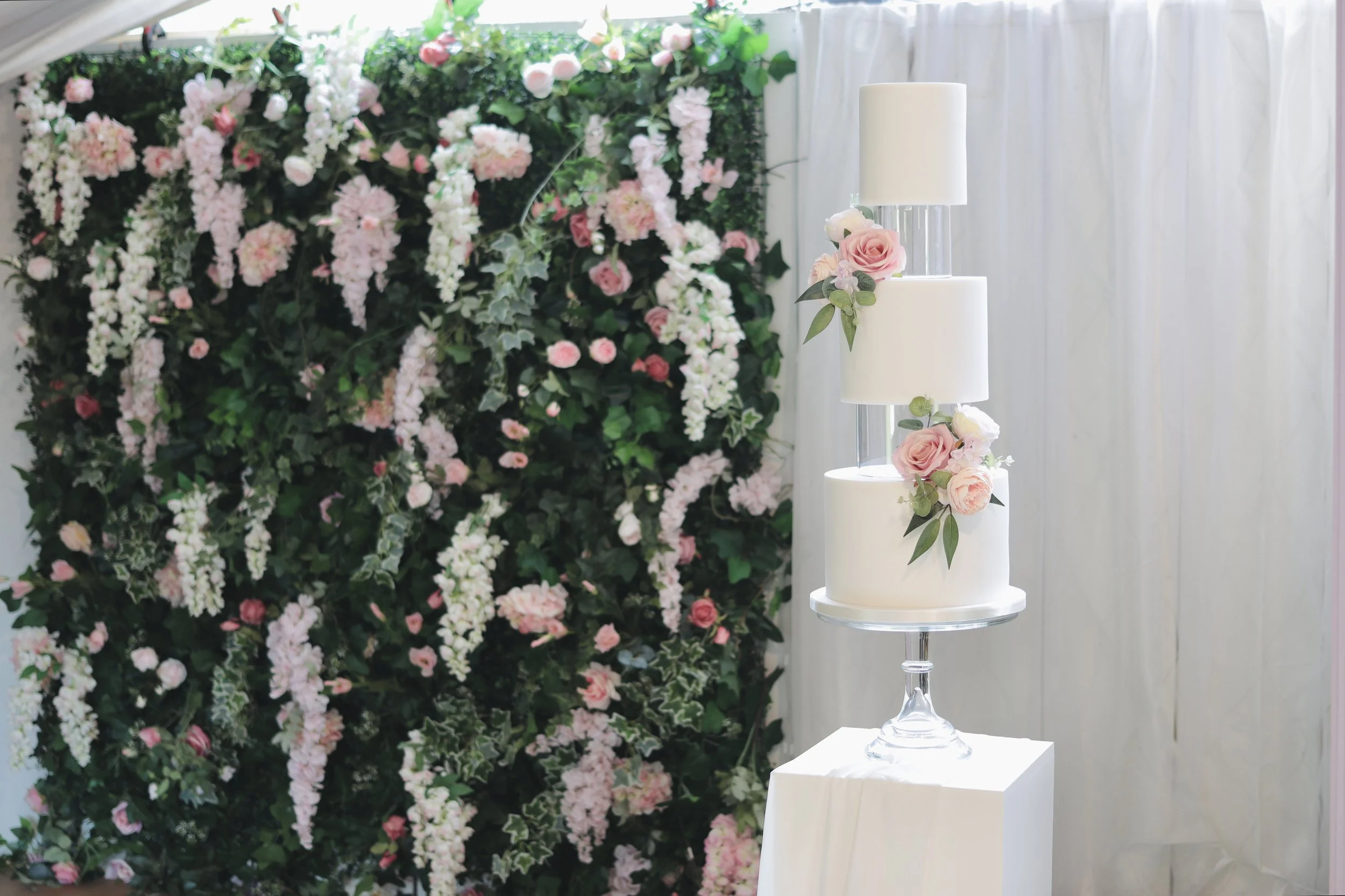 3 tier white wedding cake with floating clear acrylic spacers and artificial flowers.JPG