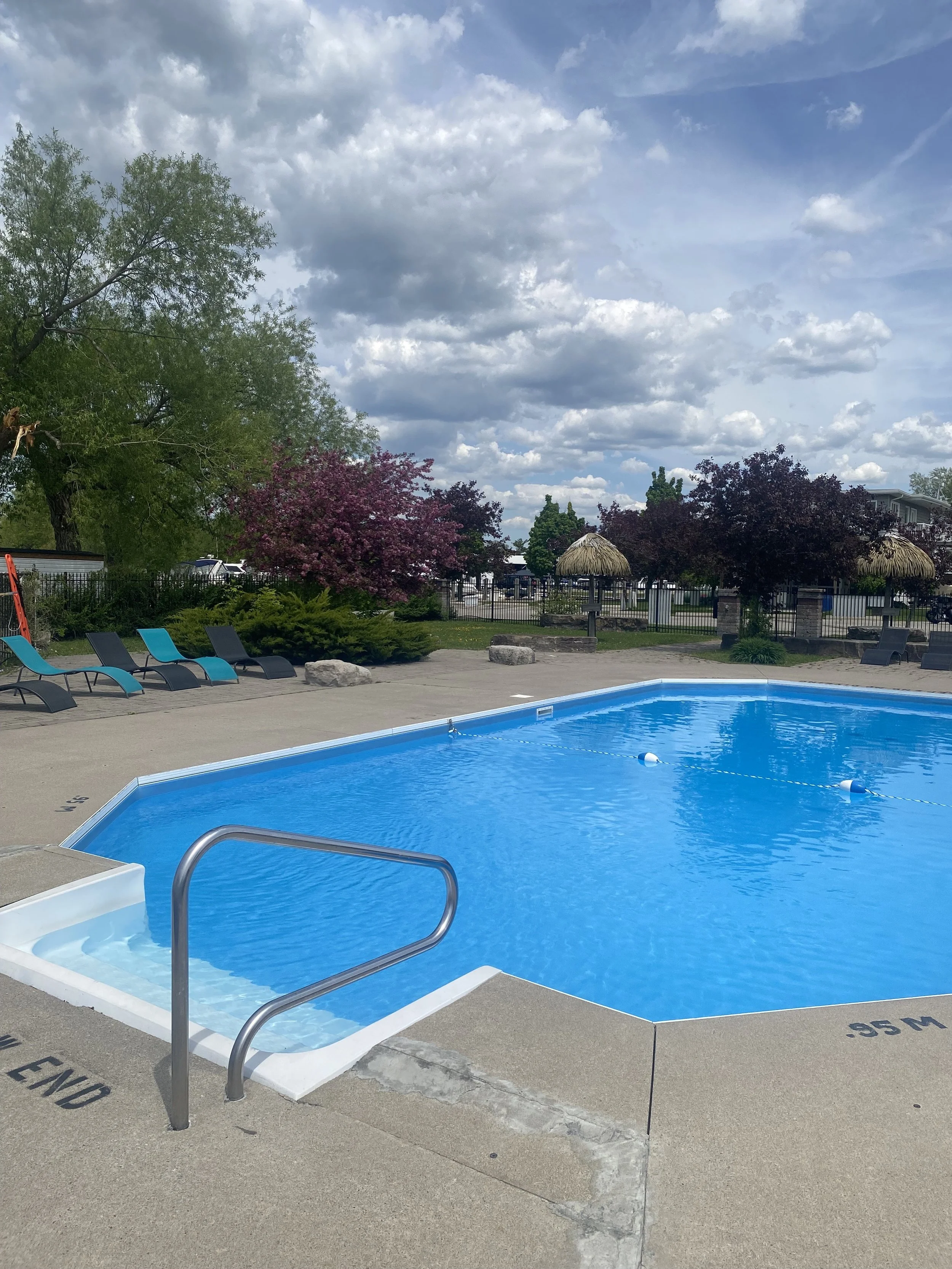 Outdoor swimming pool with blue water and surrounding lounge chairs. Krates Marina | Keswick, ON | Lake Simcoe