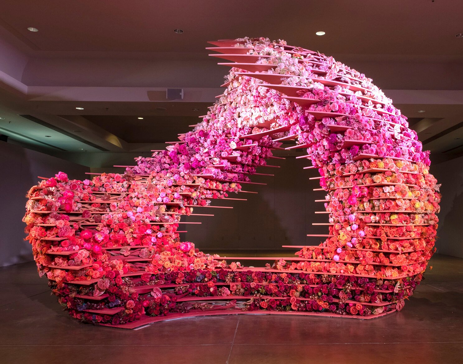 A colossal sculptural formation including more than 10,000 fresh-cut flowers, varying in size and texture, in an ombre palette inspired by the desert: terra cotta, orange, sand, pink, and blush.