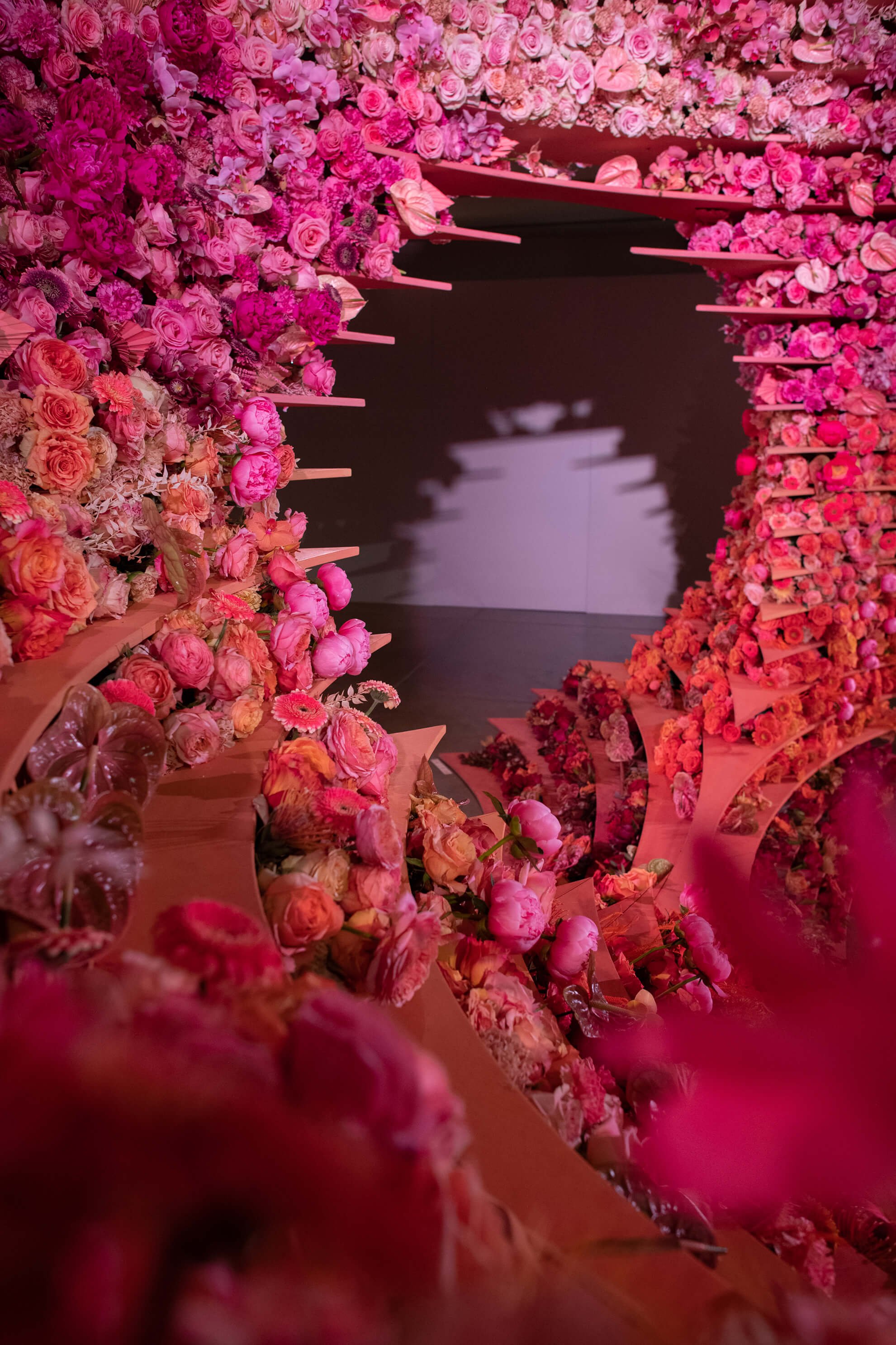 Close up view of fresh-cut flowers, varying in size and texture, in an ombre palette inspired by the desert: terra cotta, orange, sand, pink, and blush.